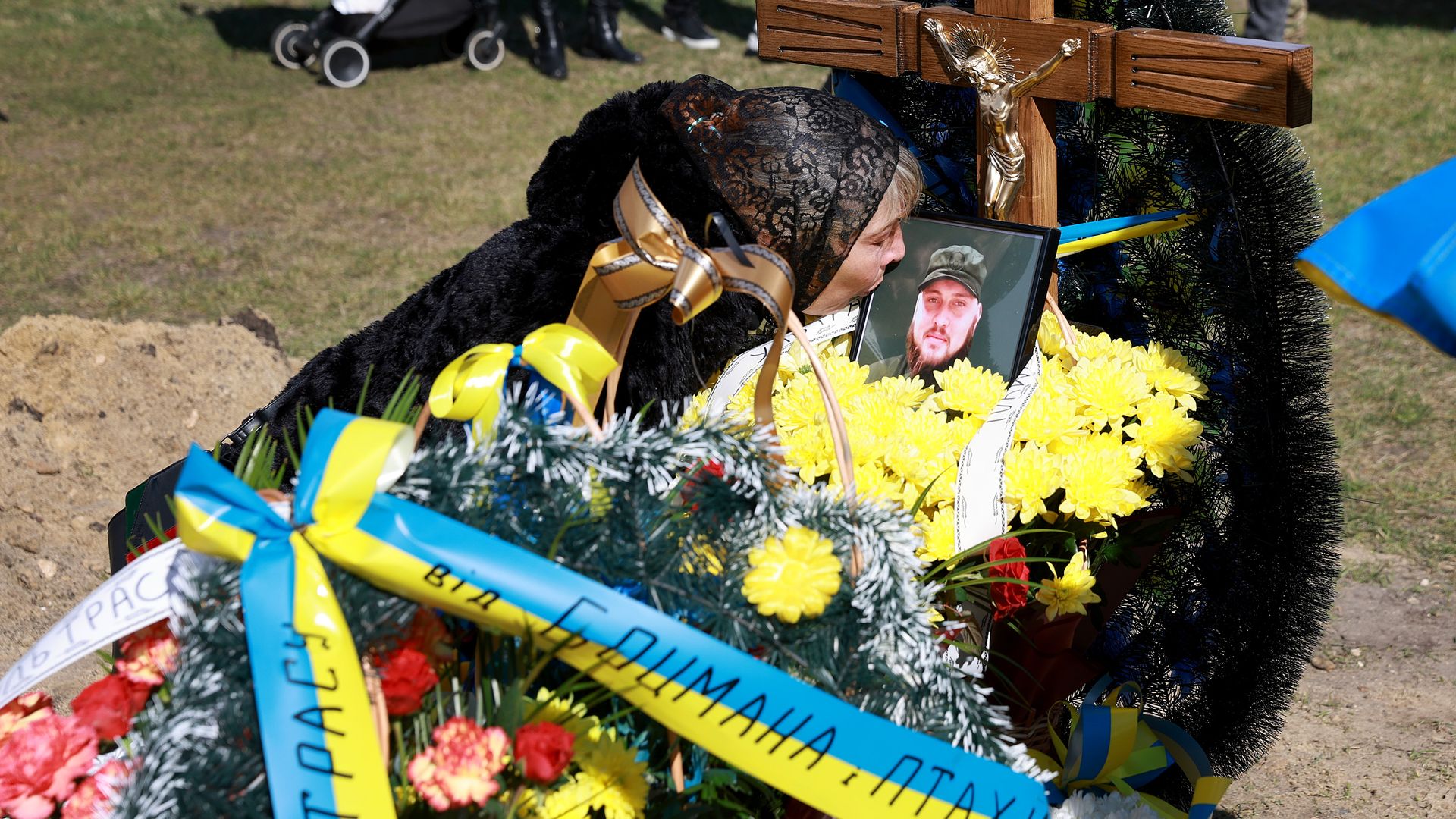 A mother kisses a photo of her son as he was buried after being killed fighting the Russians in eastern Ukraine.