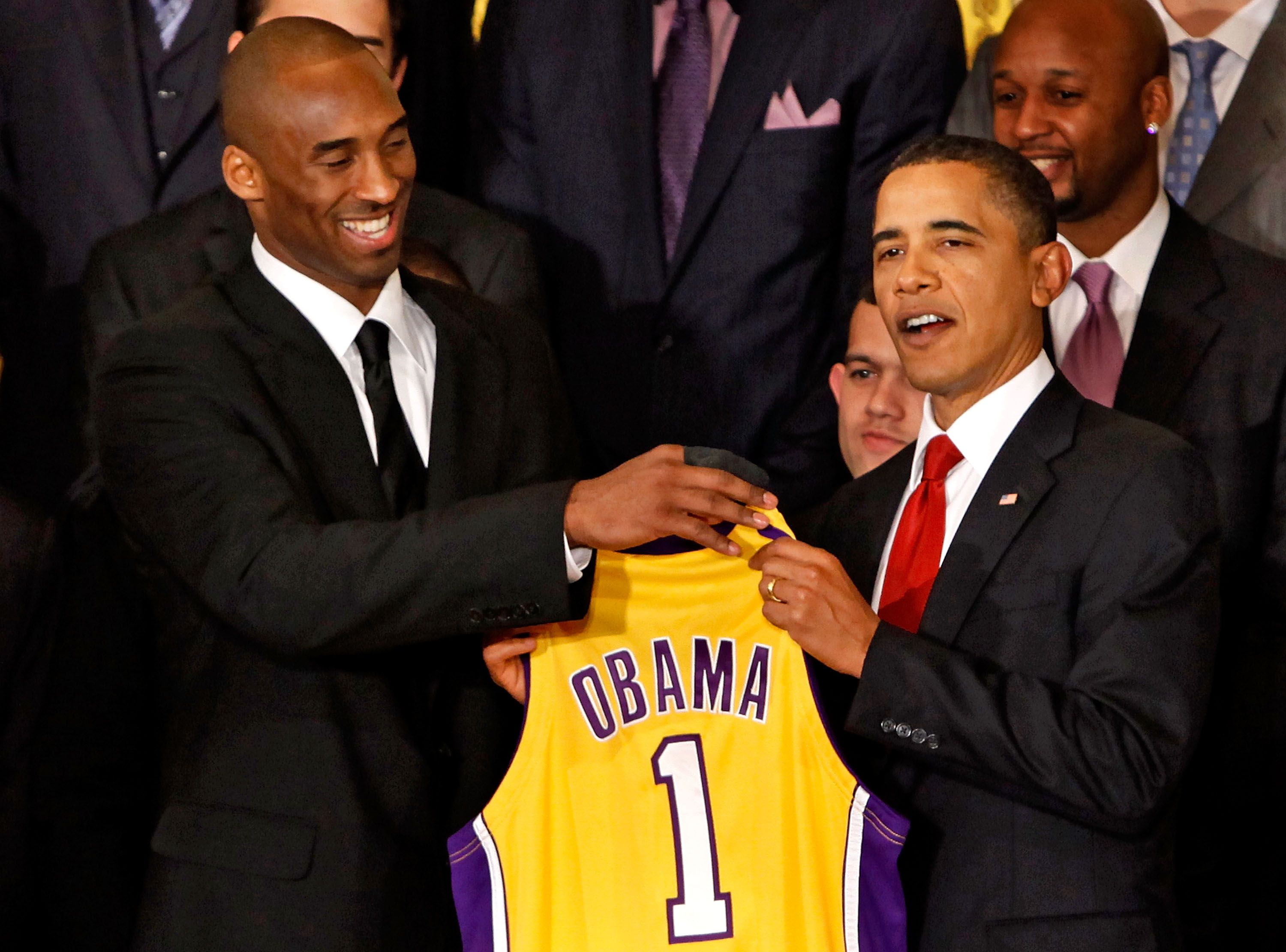 Los Angeles Lakers guard Kobe Bryant (L) presents a jersey to President Barack Obama