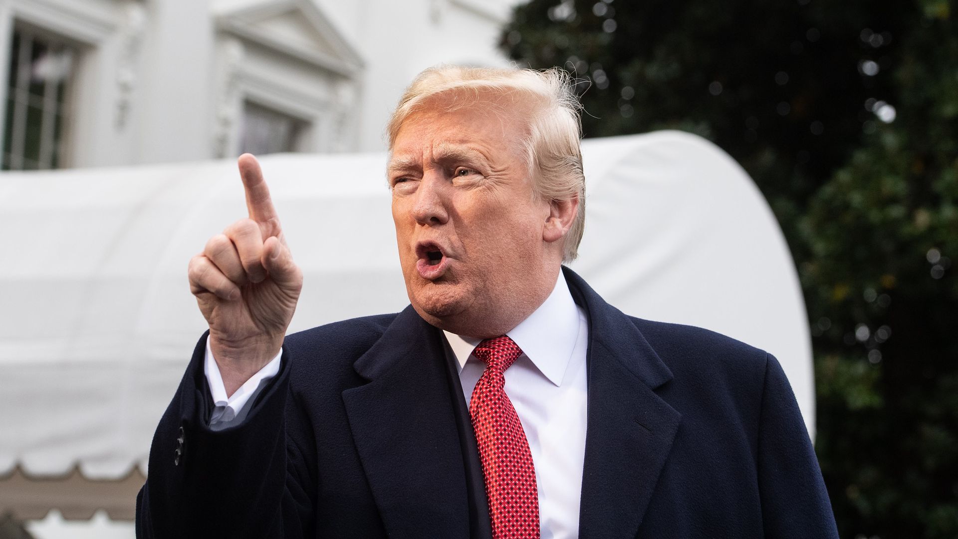 Donald Trump points his fingers at reporters while speaking on the South Lawn of the White House