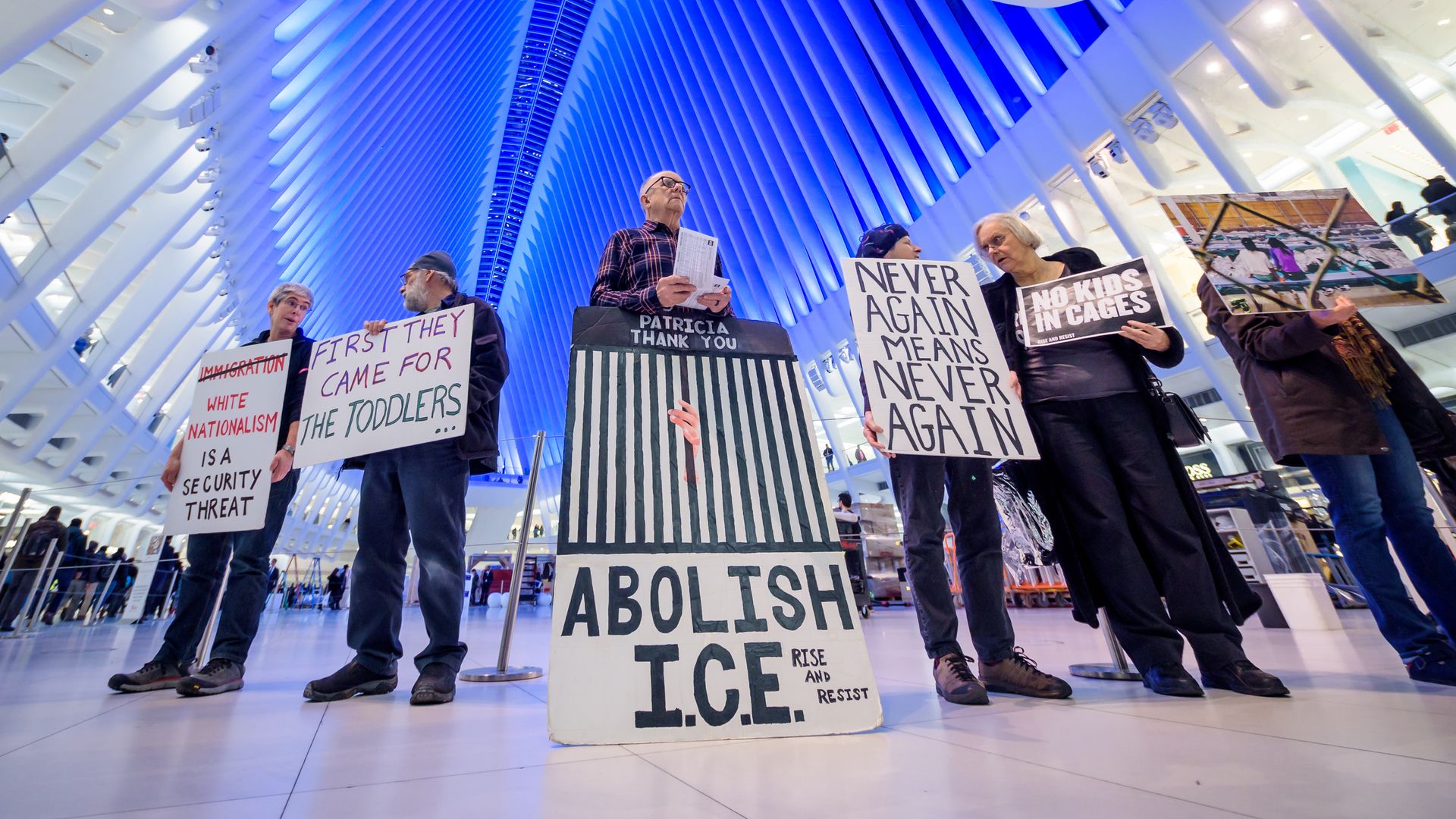 Protestors hold signs that read "abolish ICE" and other anti-ICE language