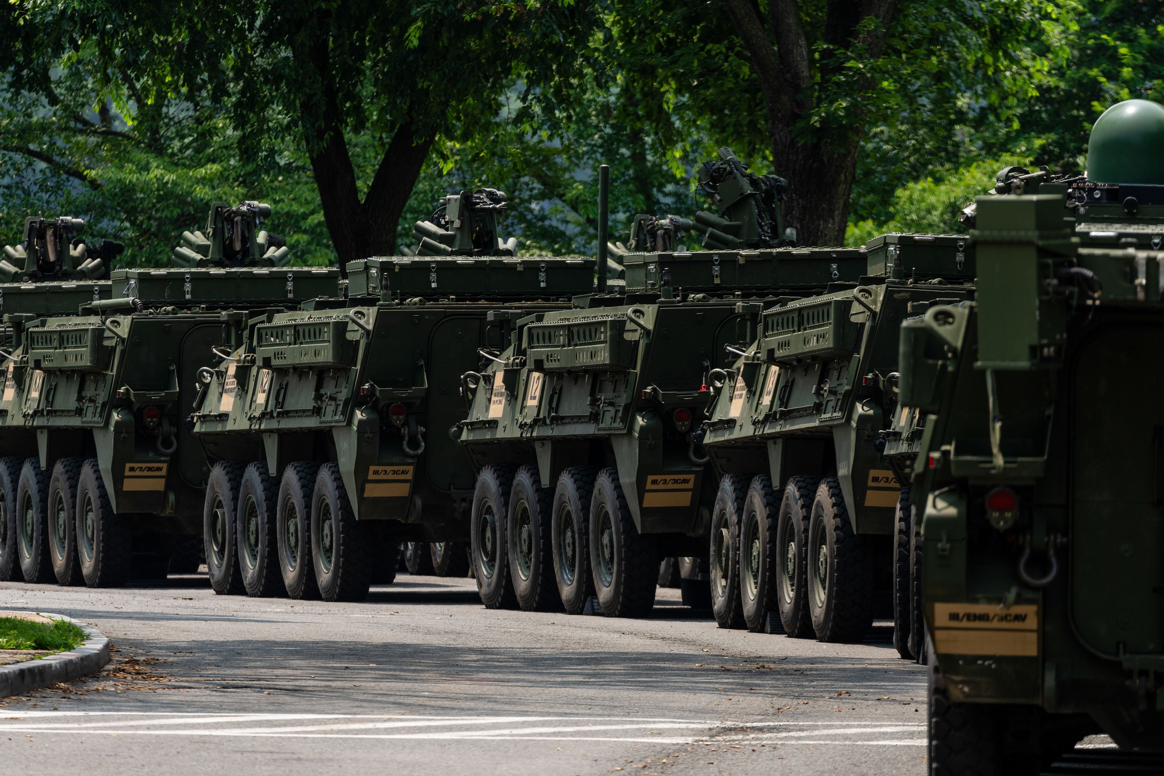 A photo shows a line of tanks driving along a road.