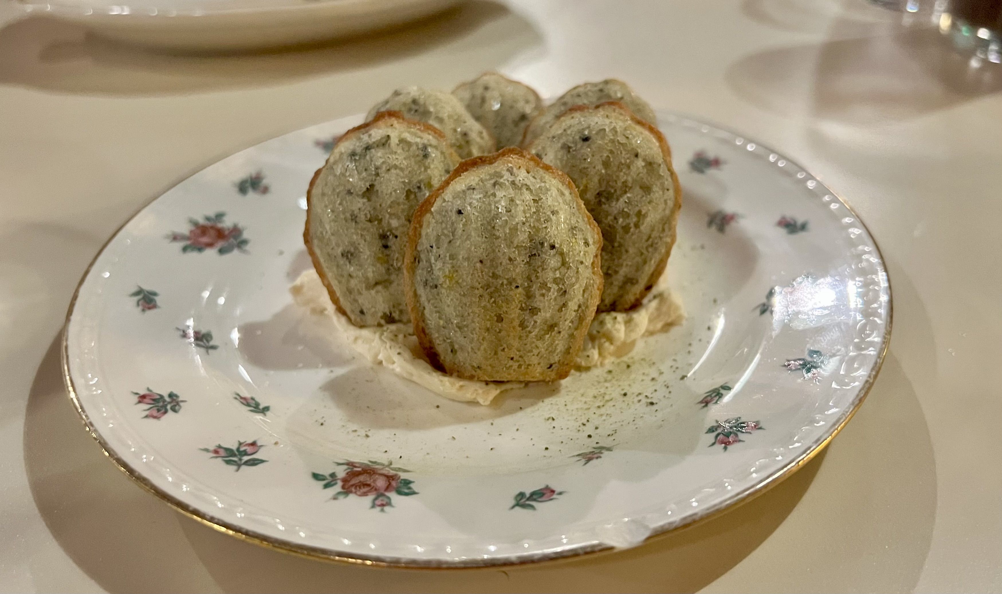 A photo of a vintage floral white plate on a white table.