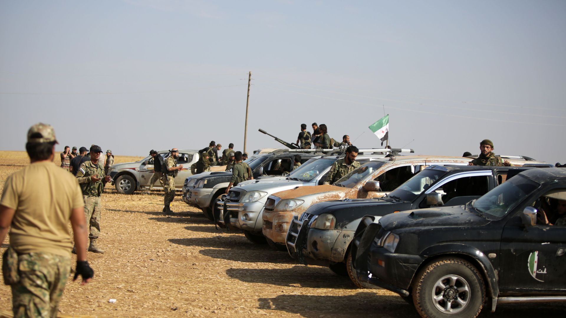 fighters in and around a small fleet of cars and trucks