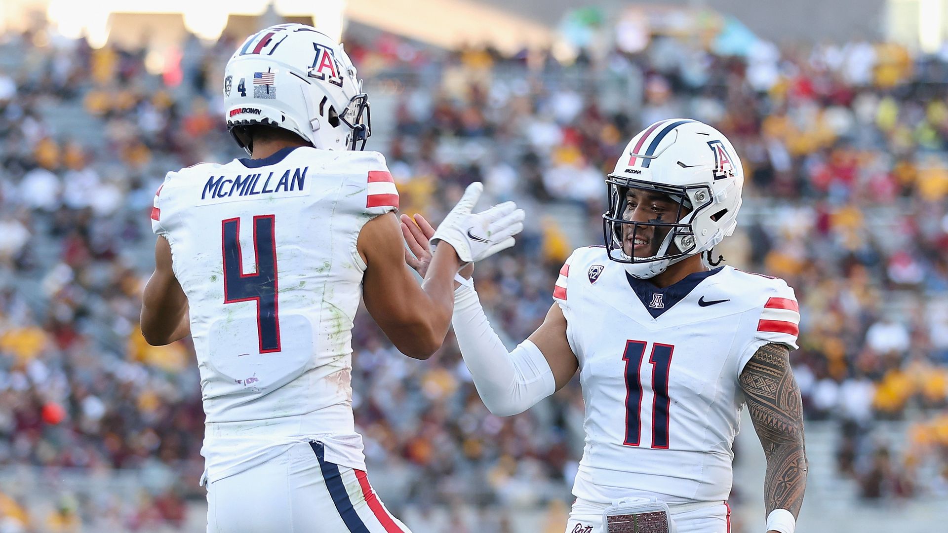 University of Arizona football players Noah Fifita and Tetairoa McMillan celebrate after a touchdown.