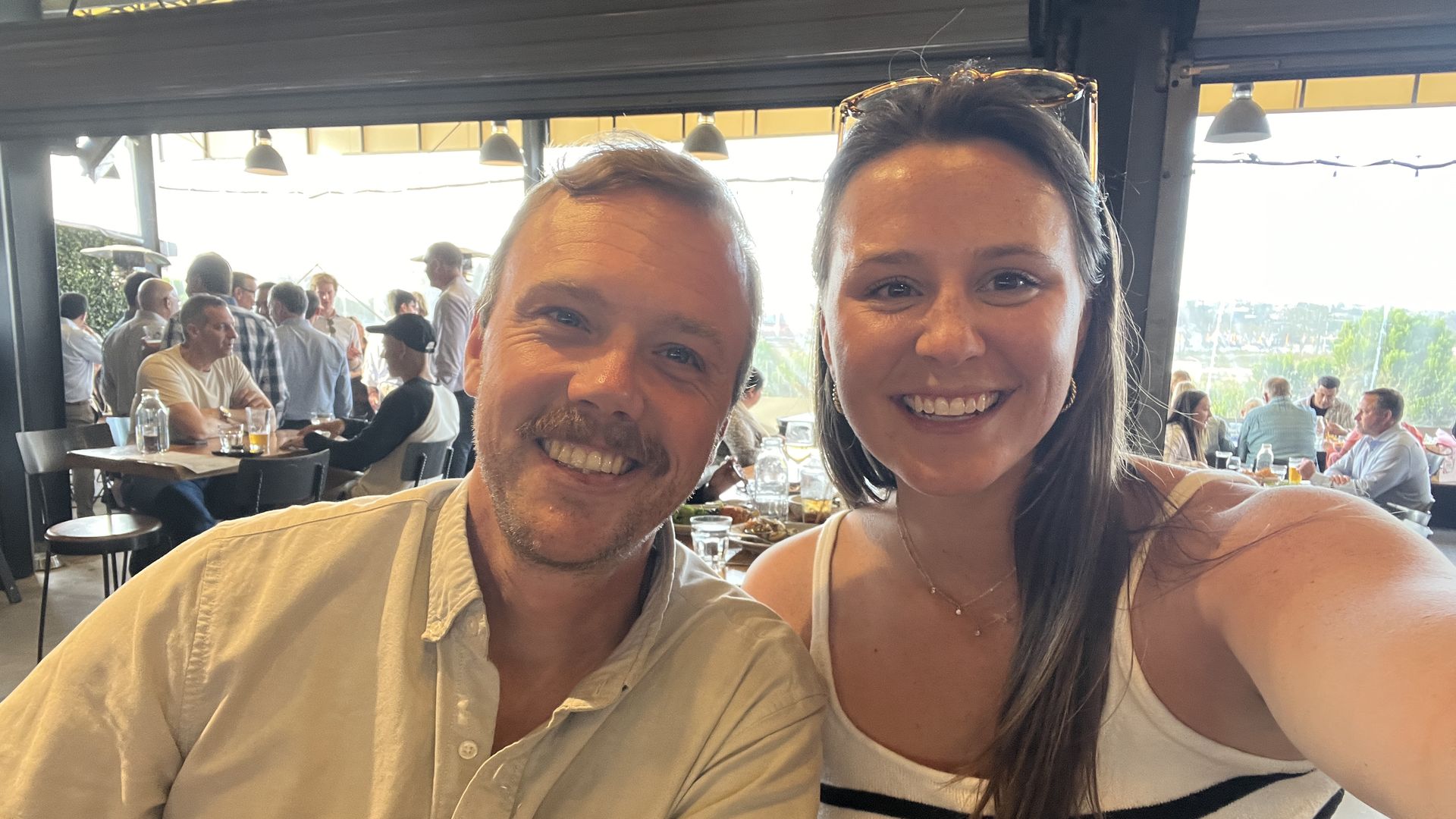 A woman takes a selfie with a man at a brewery.