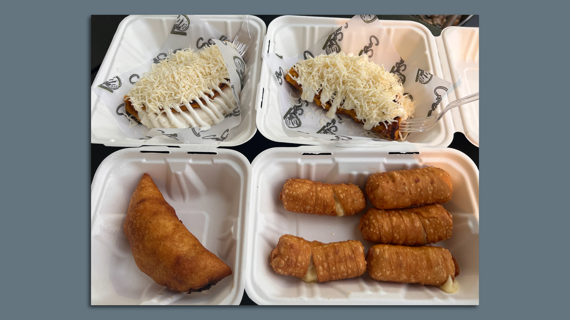 A picture of two cachapas with cheese in two separate white containers, an empanada on the bottom left and 5 tequeños on the bottom right.