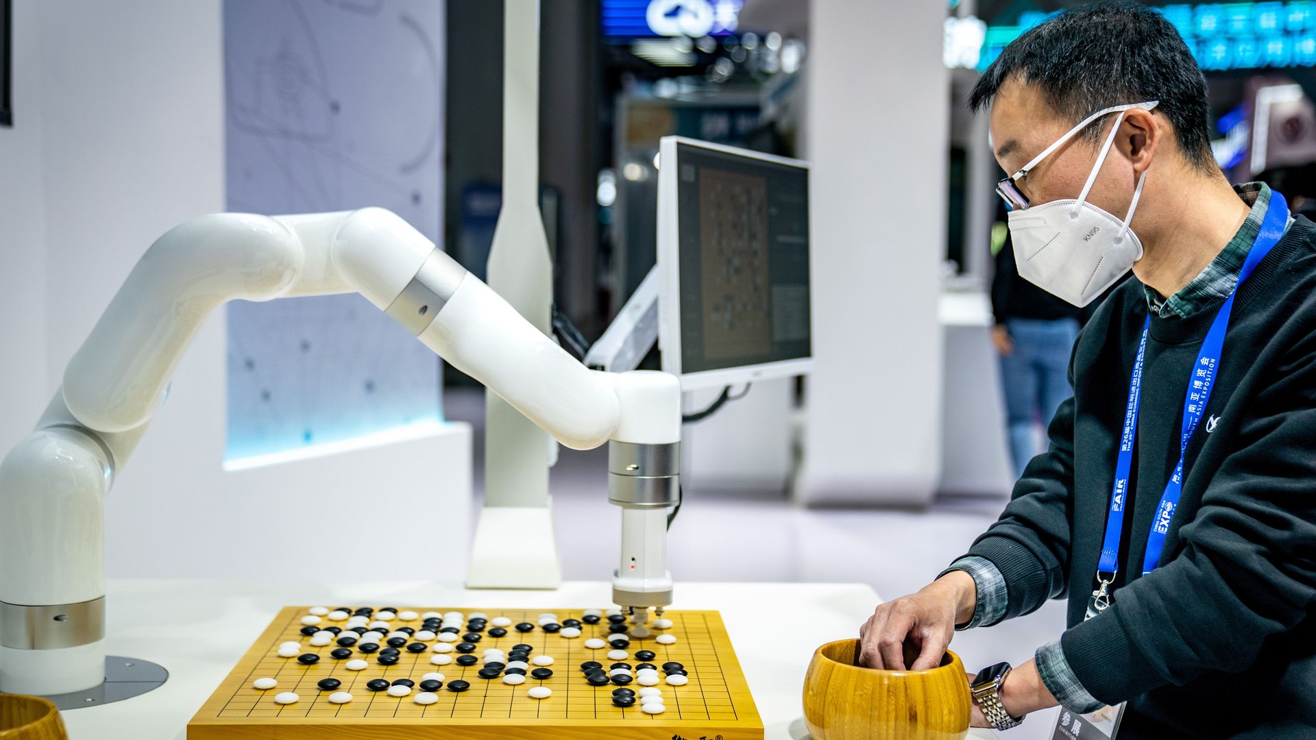 A man plays a game of Go against a robot.
