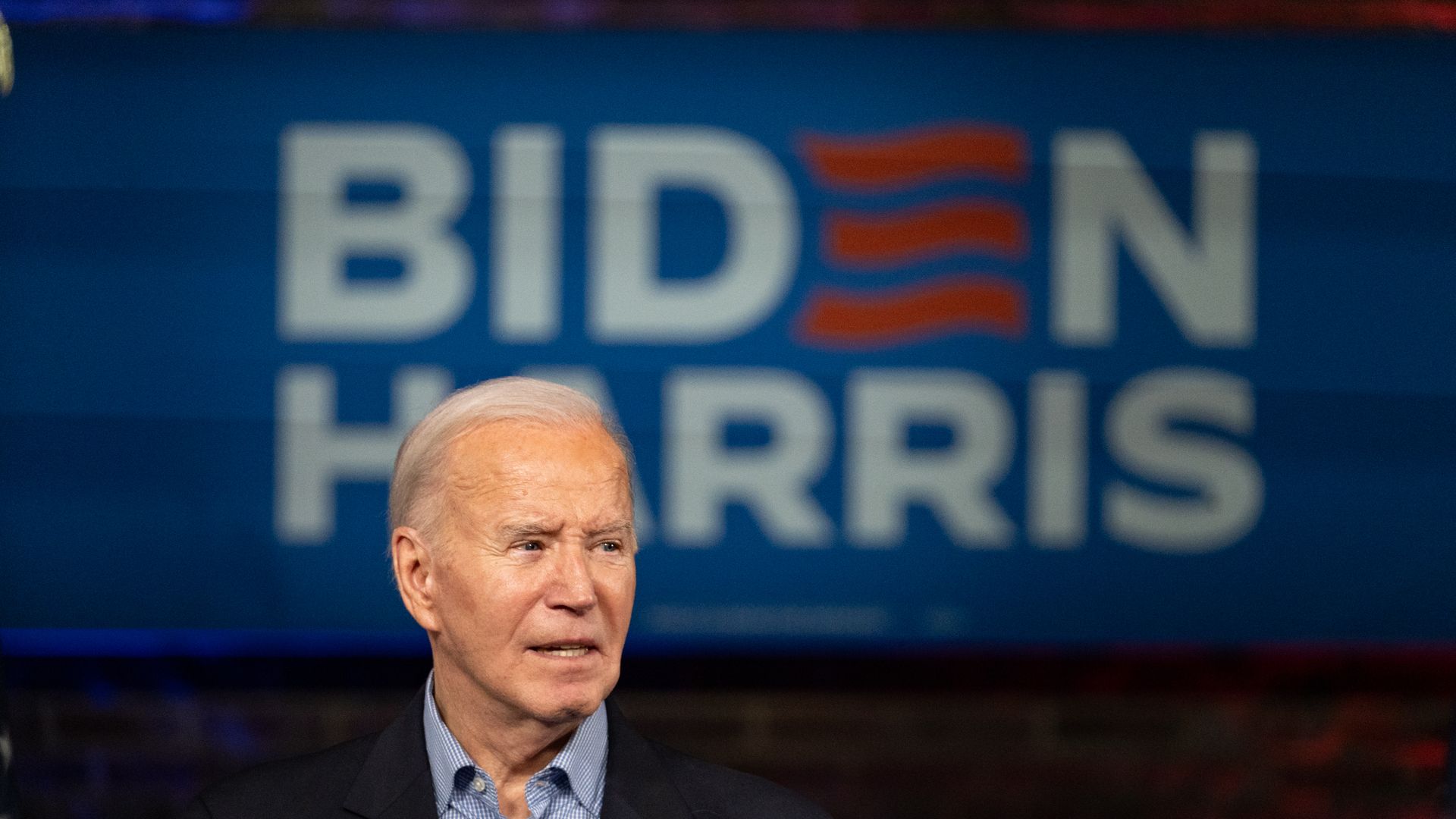 Joe Biden in front of Biden Harris sign