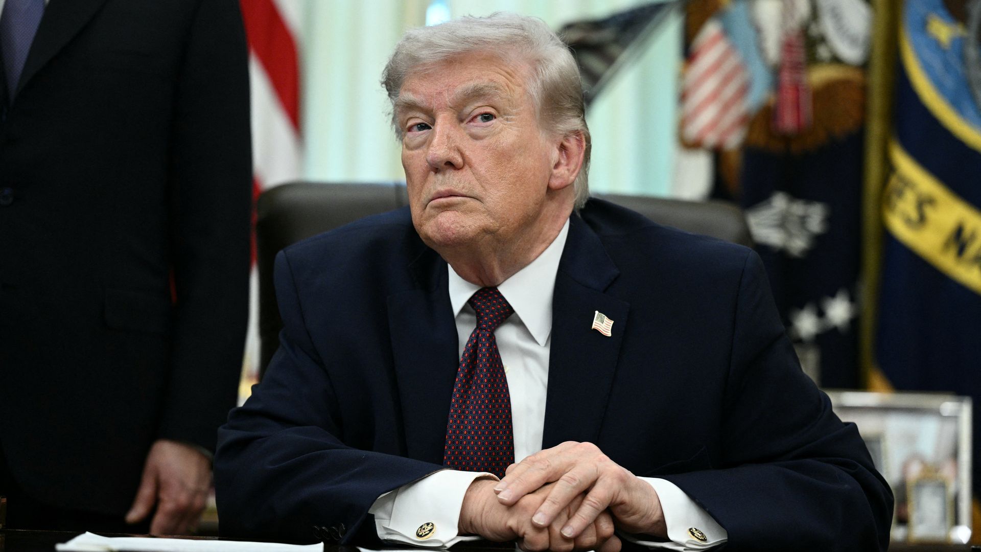 Donald Trump sitting behind a desk.