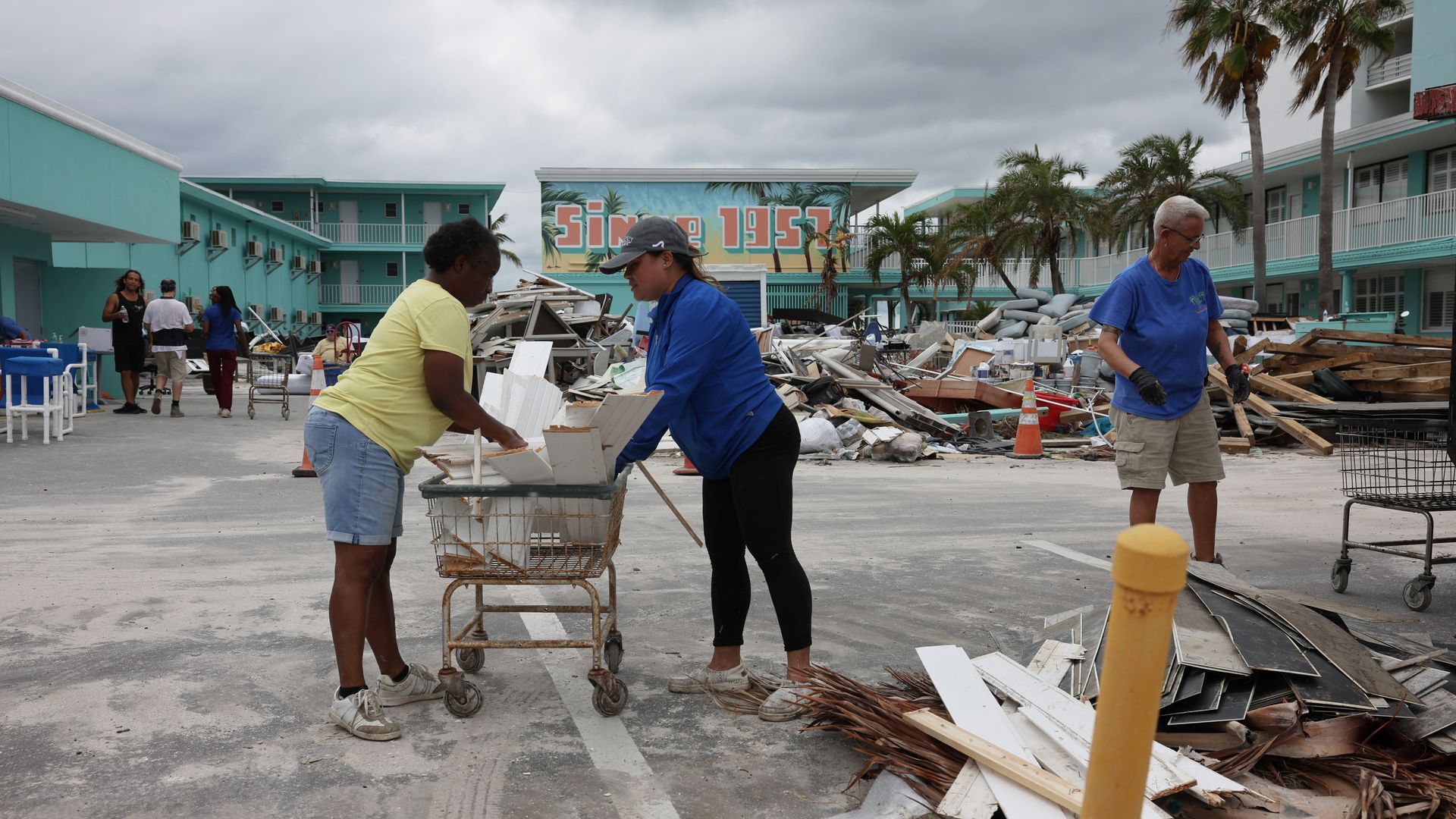 Image shows people cleaning up debris in Florida.