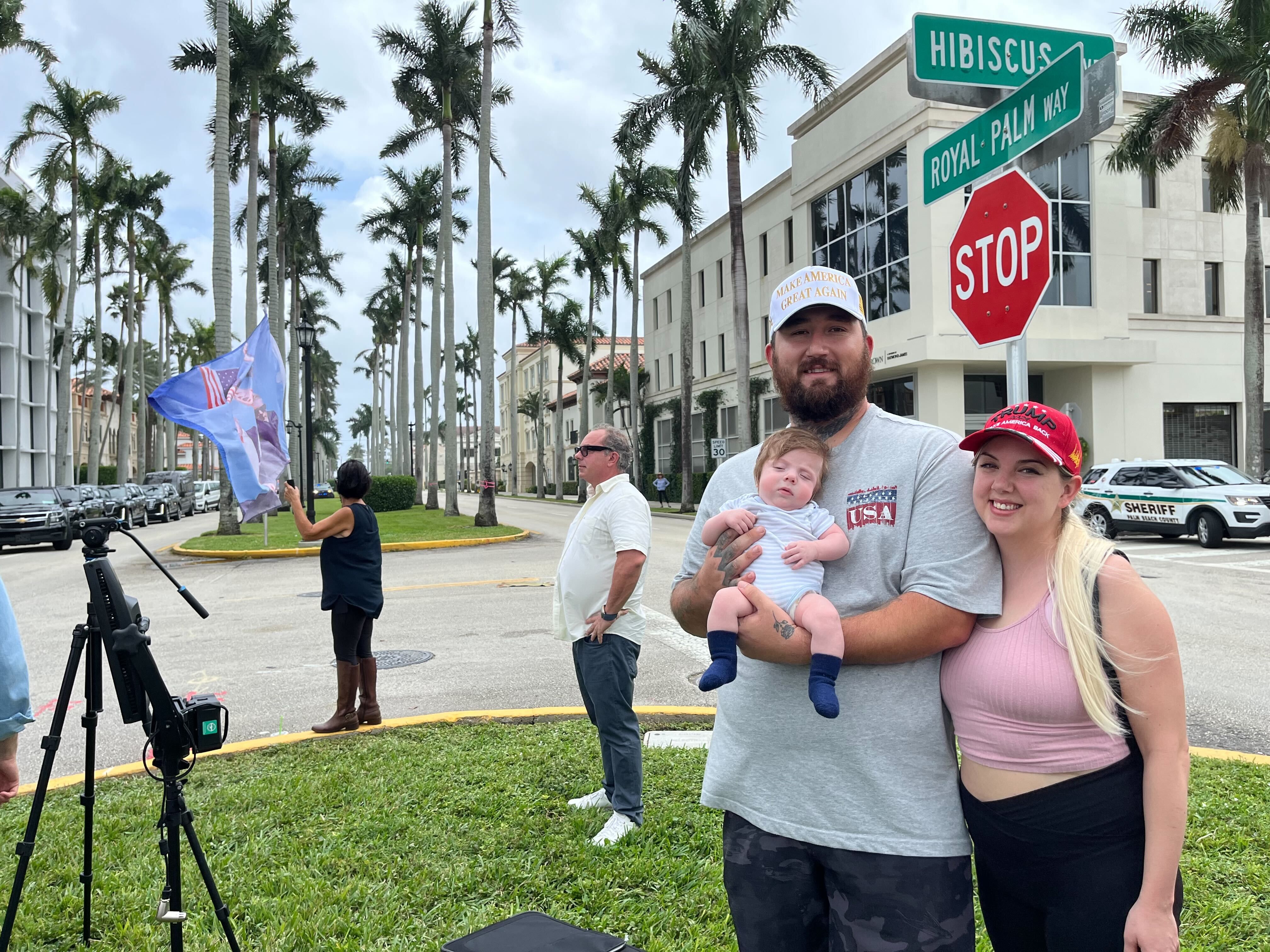 father and mother hold baby