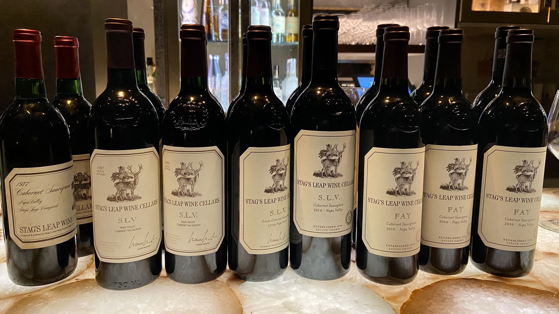 Bottles of wine lined up on a bar