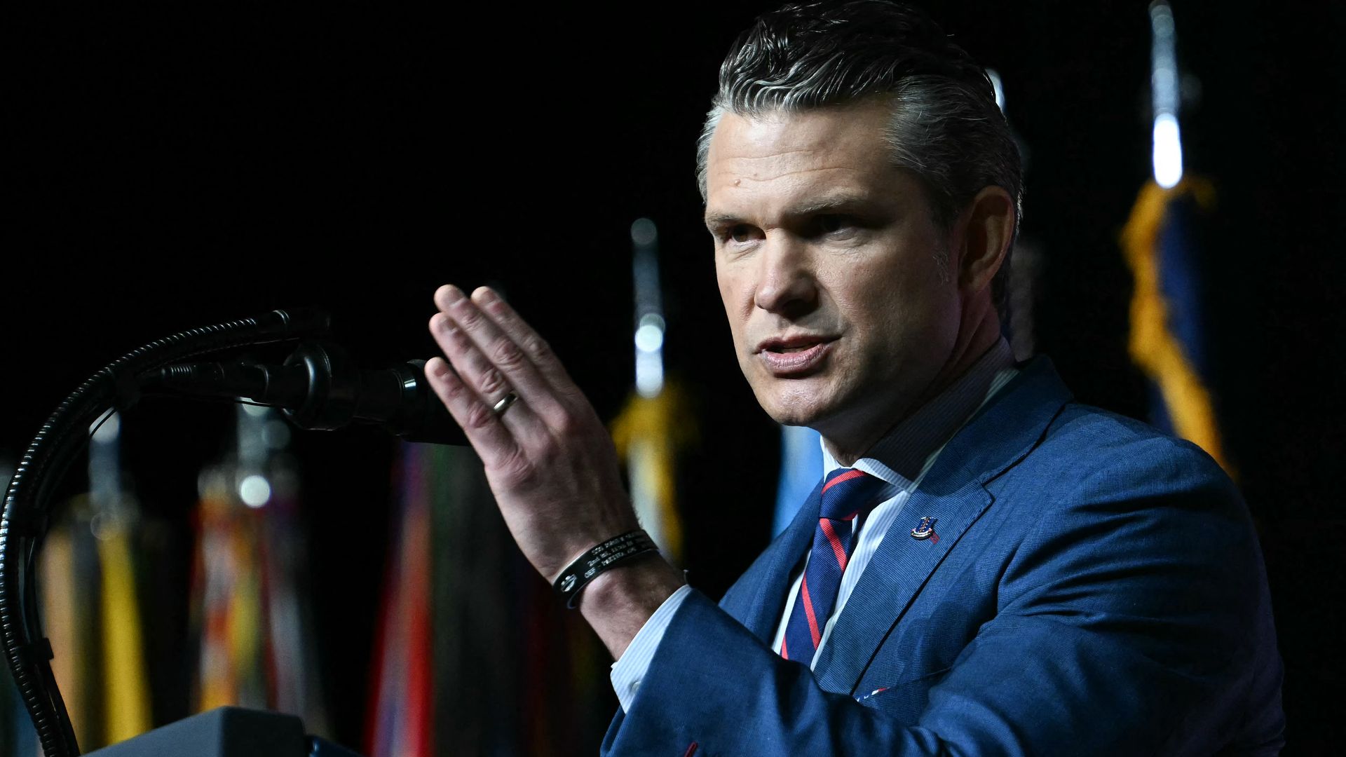 Defense Secretary Pete Hegseth speaks at a podium while introducing President Trump to senior military officers at Marine Corps Base Quantico.