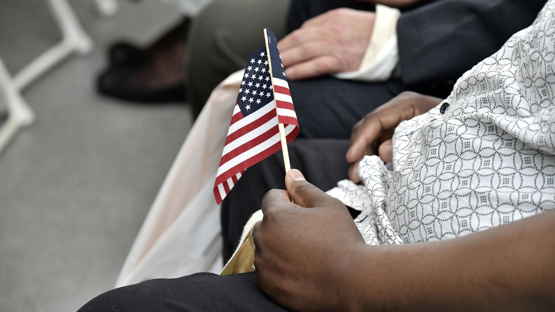 An attendee holds an American flag at a United States naturalization ceremony
