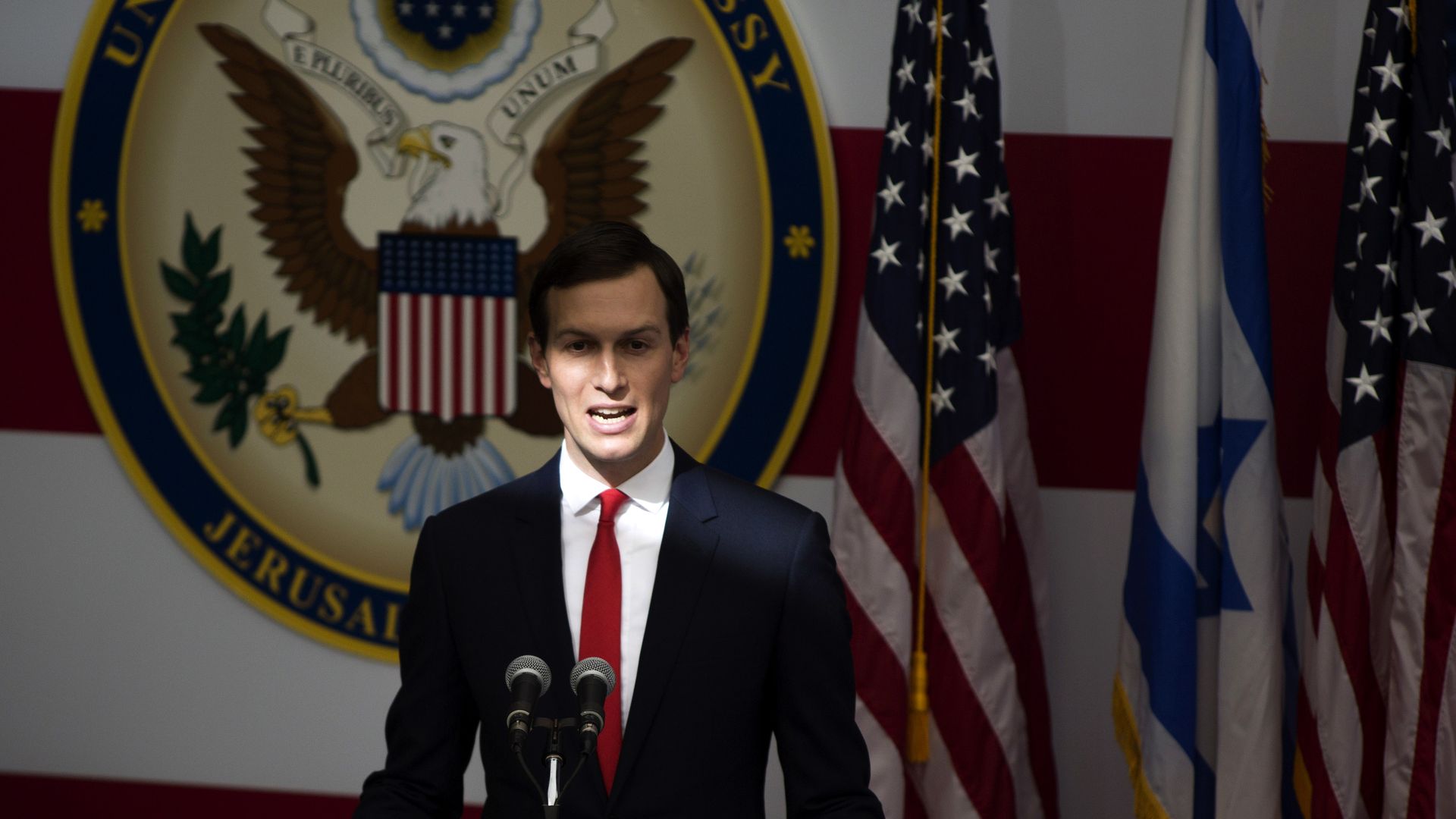 Kushner stands behind a podium