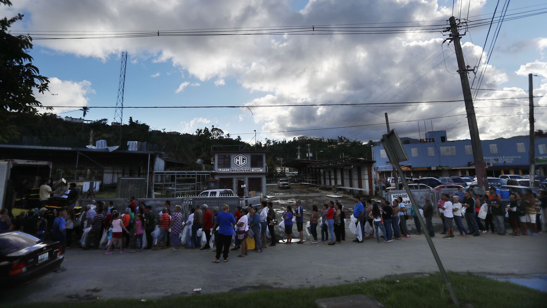 A long line of people stand outside