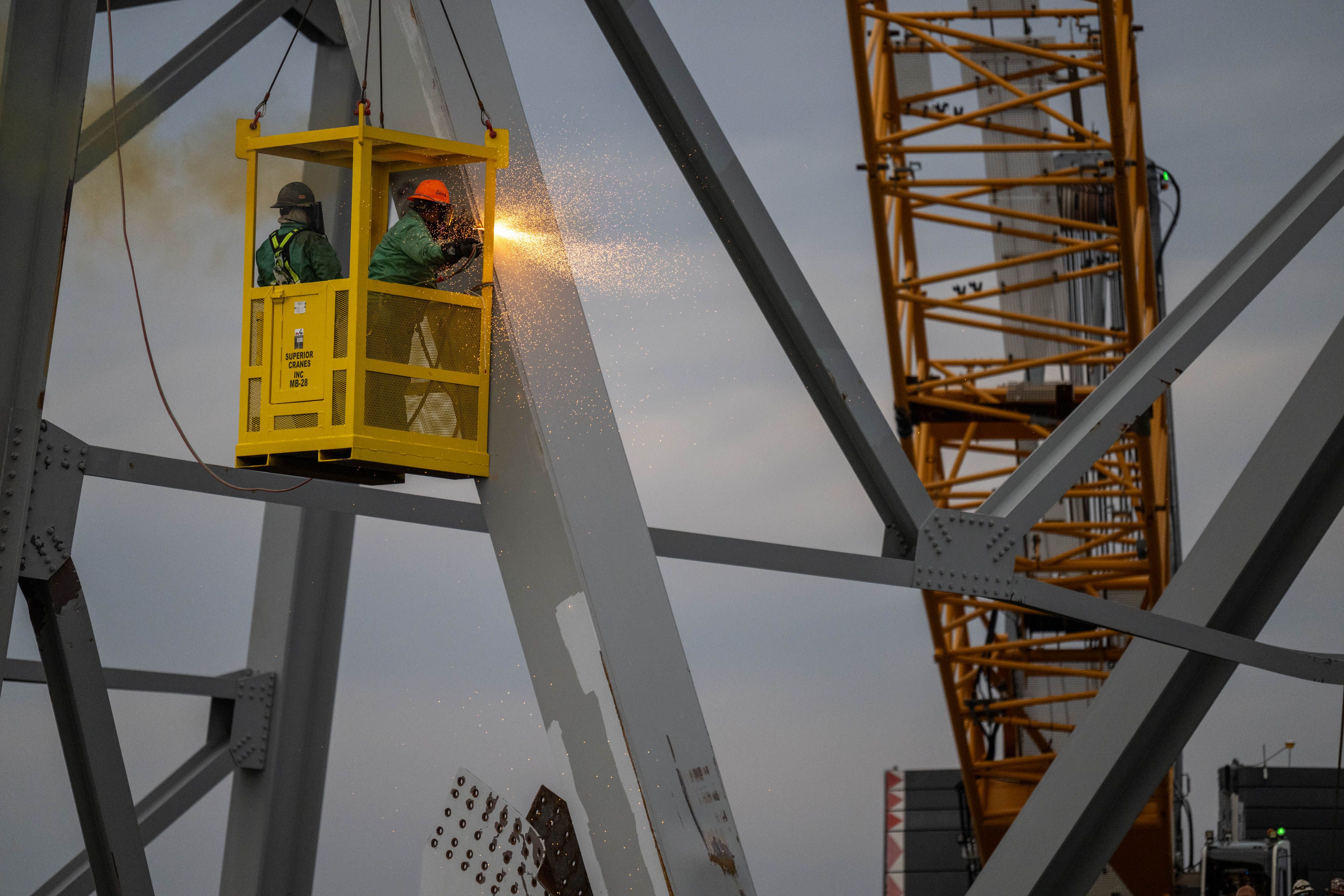 Demolition crews cut the top portion of the north side of the collapsed Francis Scott Key Bridge on Saturday.