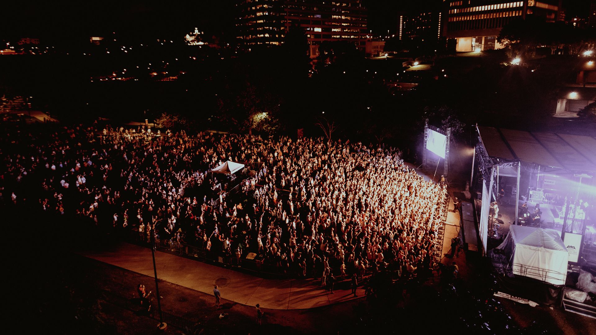 a huge crowd of people at an outdoor concert 