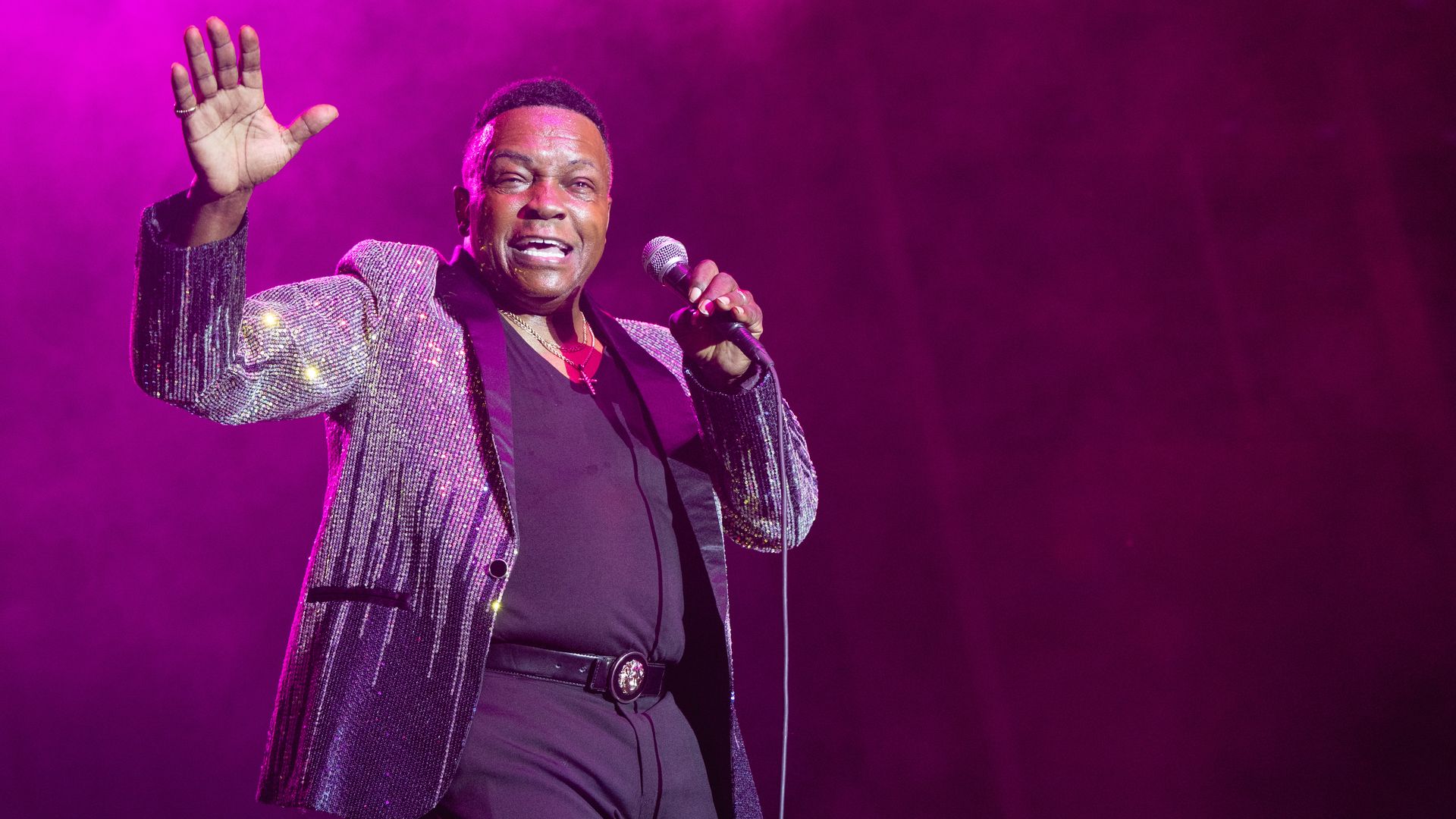 Lee Fields performing against a purple background in Austin, Texas