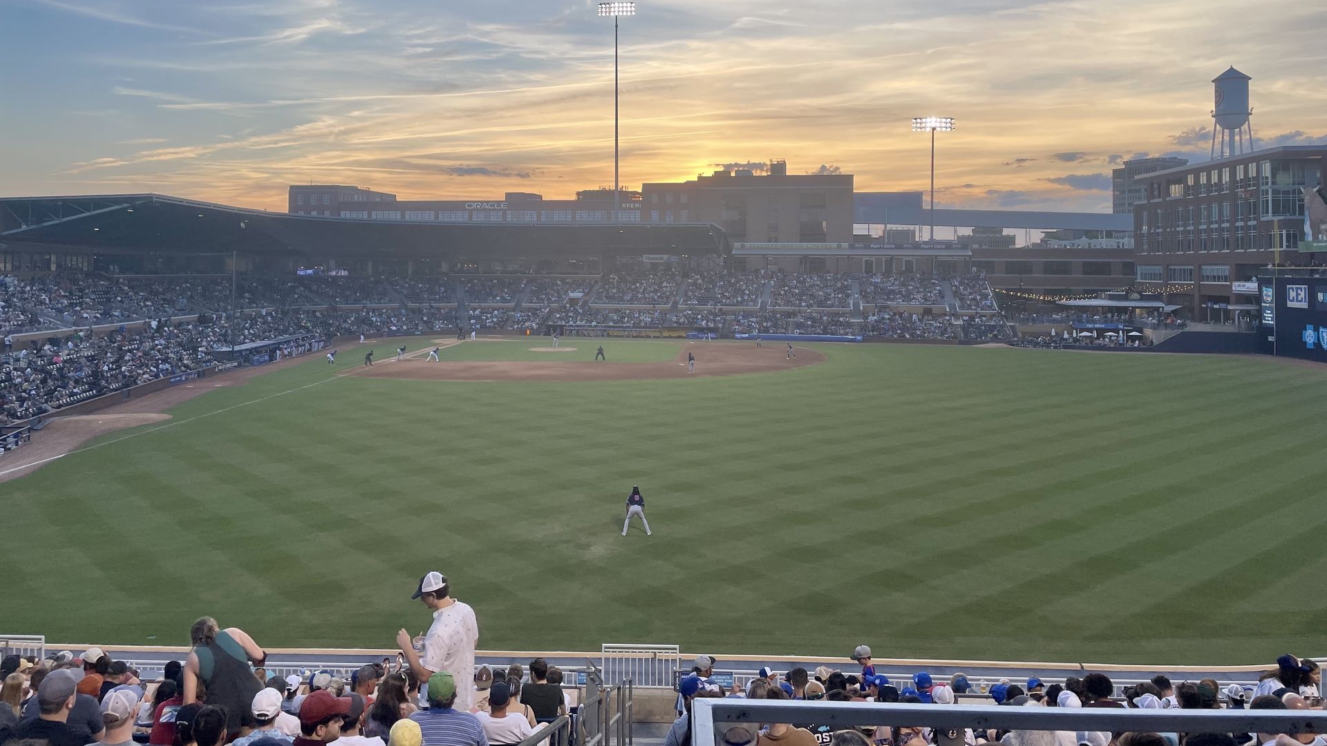 The Durham Bulls Athletic Park, as seen from the outfield, with a sunset in the distance.