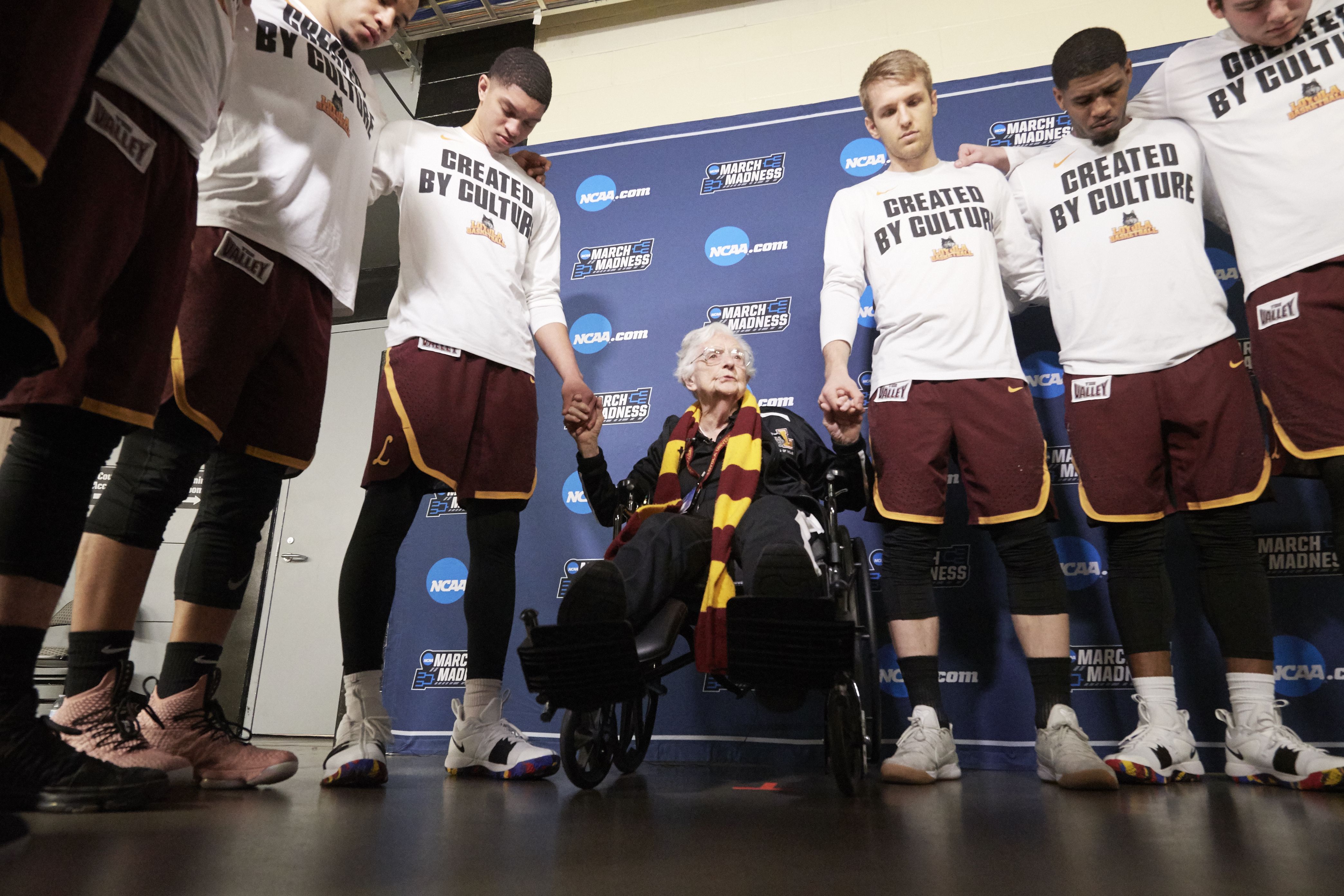 Sister Jean and Loyola Chicago players stand in prayer. 