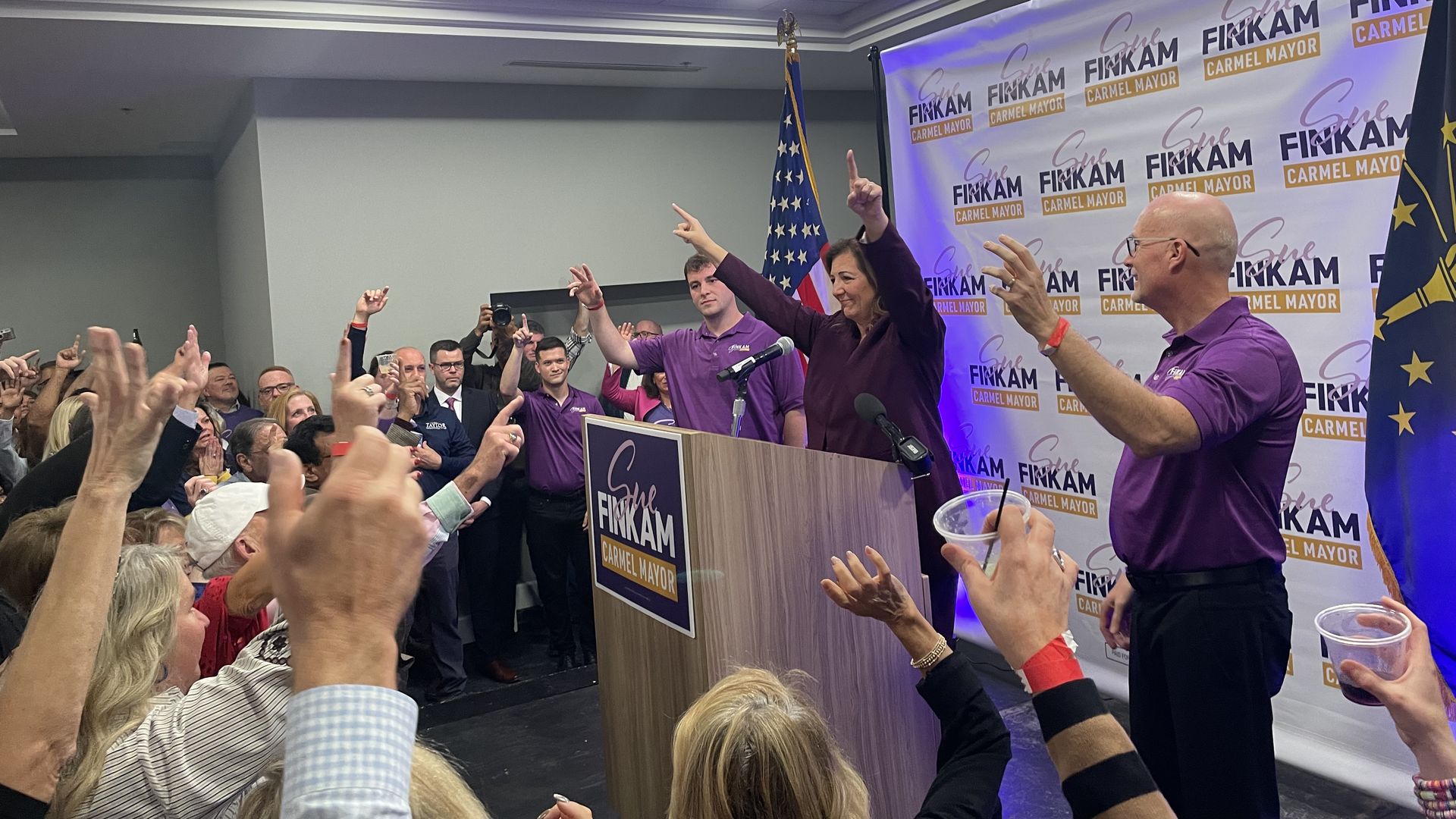 Sue Finkam points her fingers upward among family and supporters during a victory speech after winning the Carmel mayoral election.