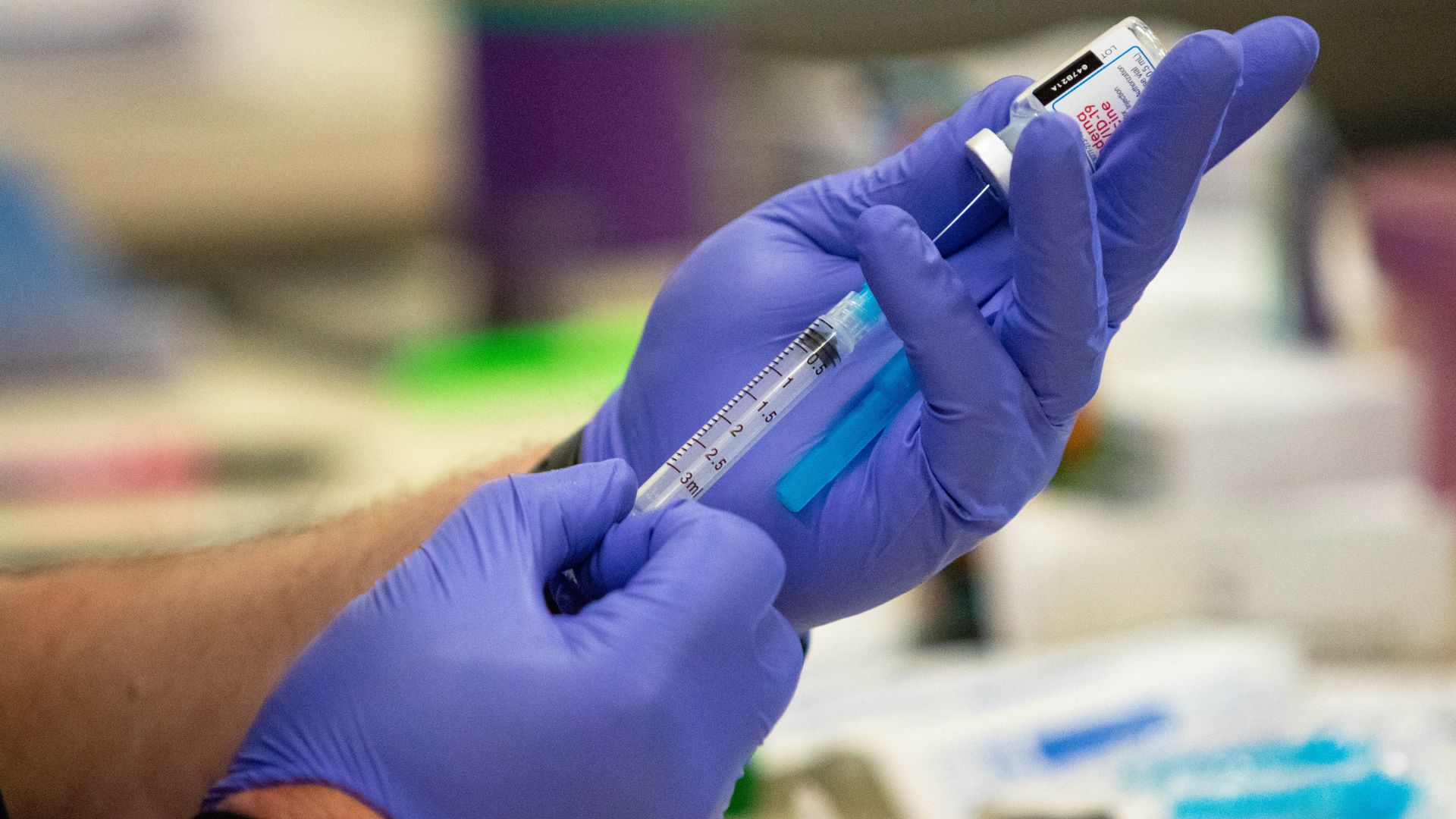 Fire department staff draws COVID-19 Moderna vaccine from an ampule into a syringe during the event.