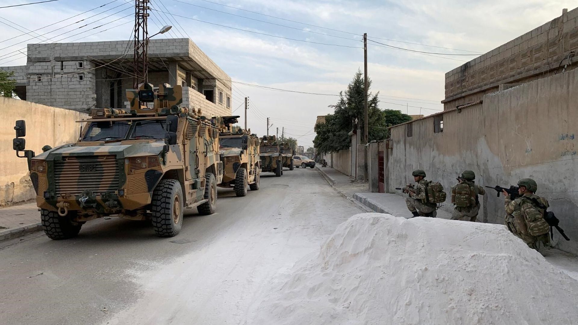 Turkish soldiers posted along a road in a Syrian border town