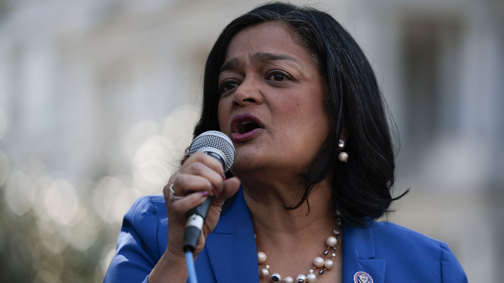 Rep. Jayapal speaks into a microphone.