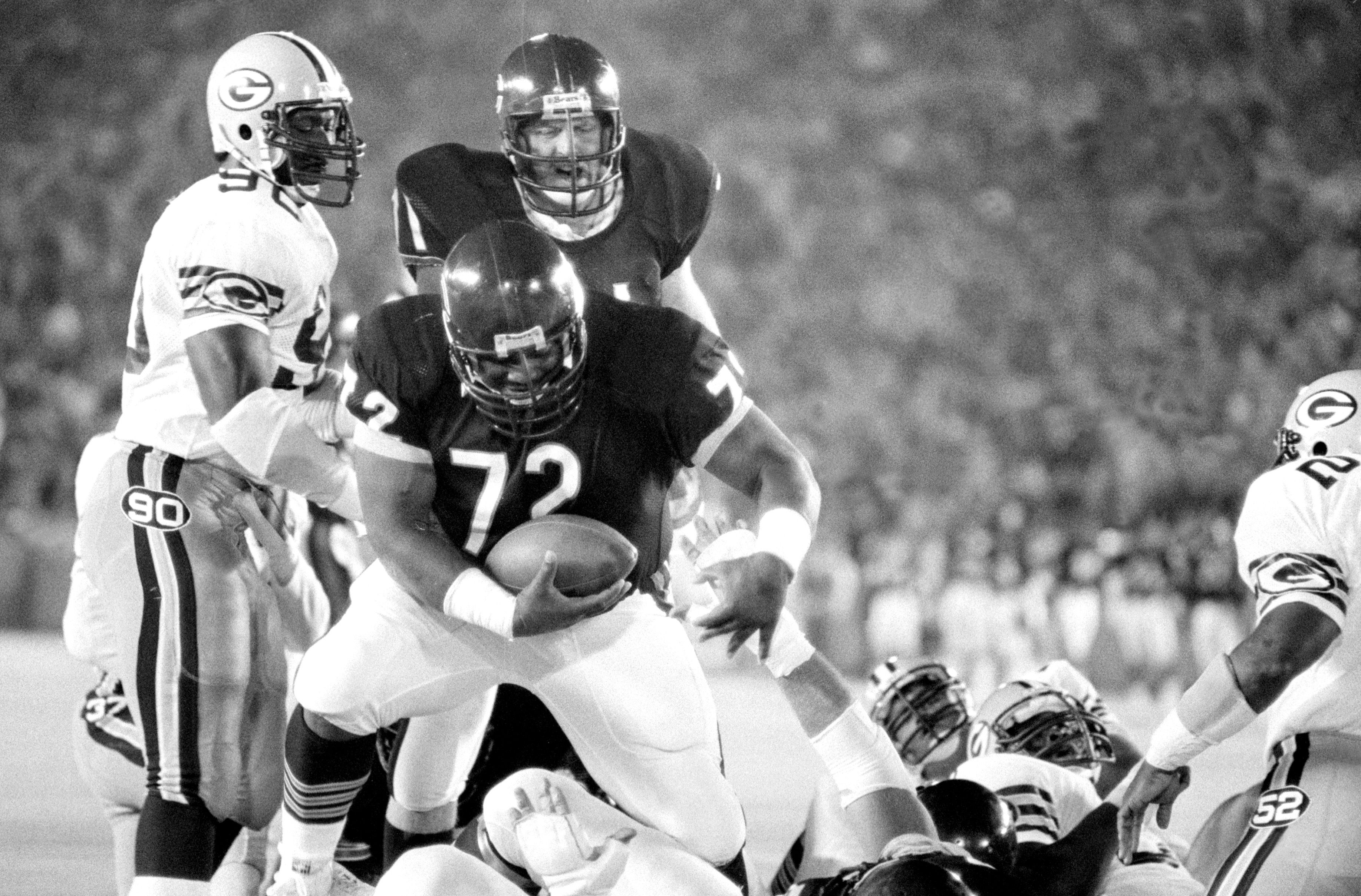 Photo of a football player dancing with a football in his hand during a game. 