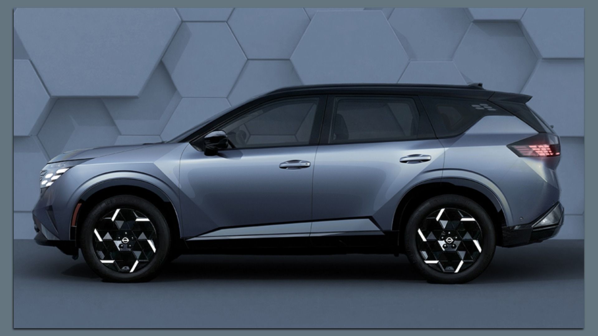 Side view of futuristic silver 2027 Nissan Rogue Hybrid e-Power SUV with a black roof and distinctive geometric alloy wheels, set against a hexagonal-tiled wall.