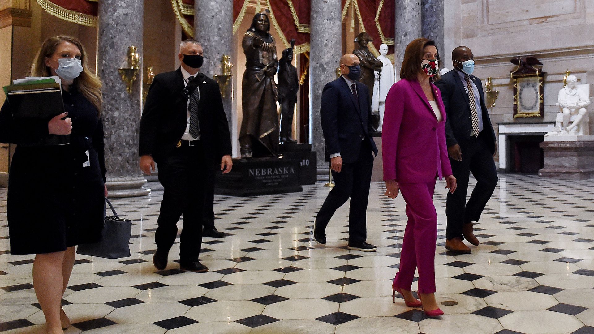 In this image, Nancy Pelosi walks ahead of others 