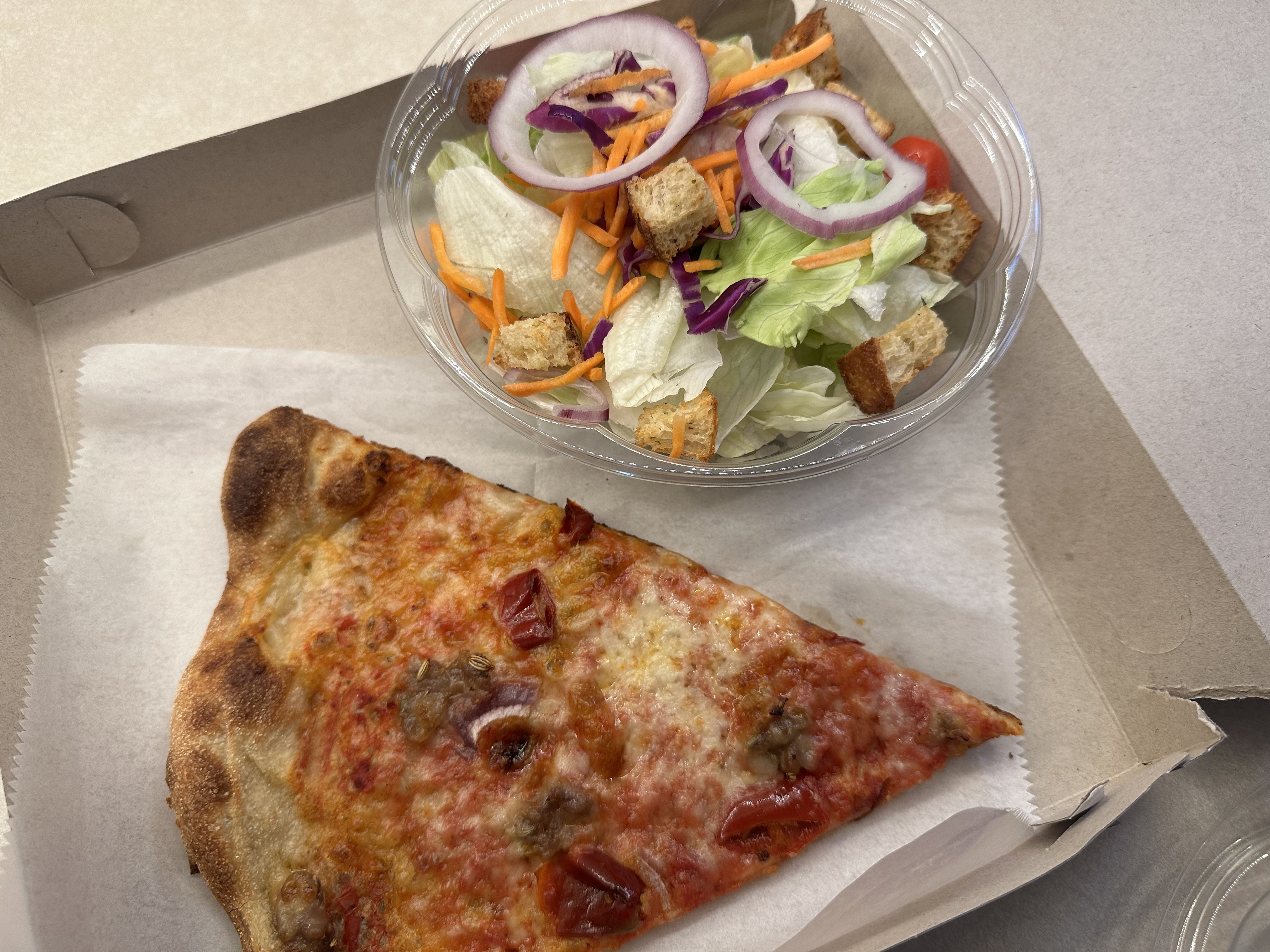A slice of pizza and salad 