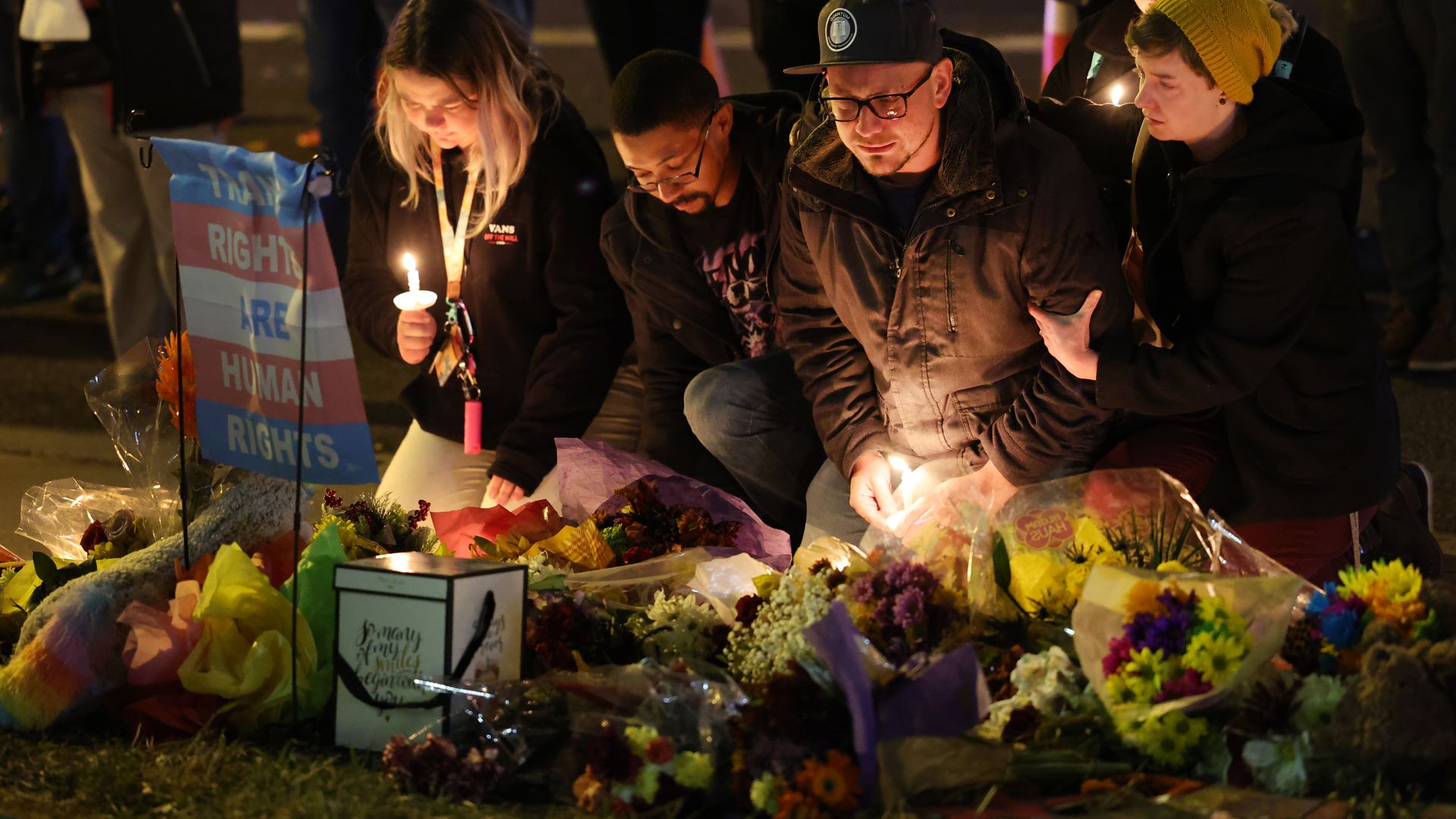 People hold a vigil at a makeshift memorial near the Club Q nightclub on November 20, 2022 in Colorado Springs, Colorado.