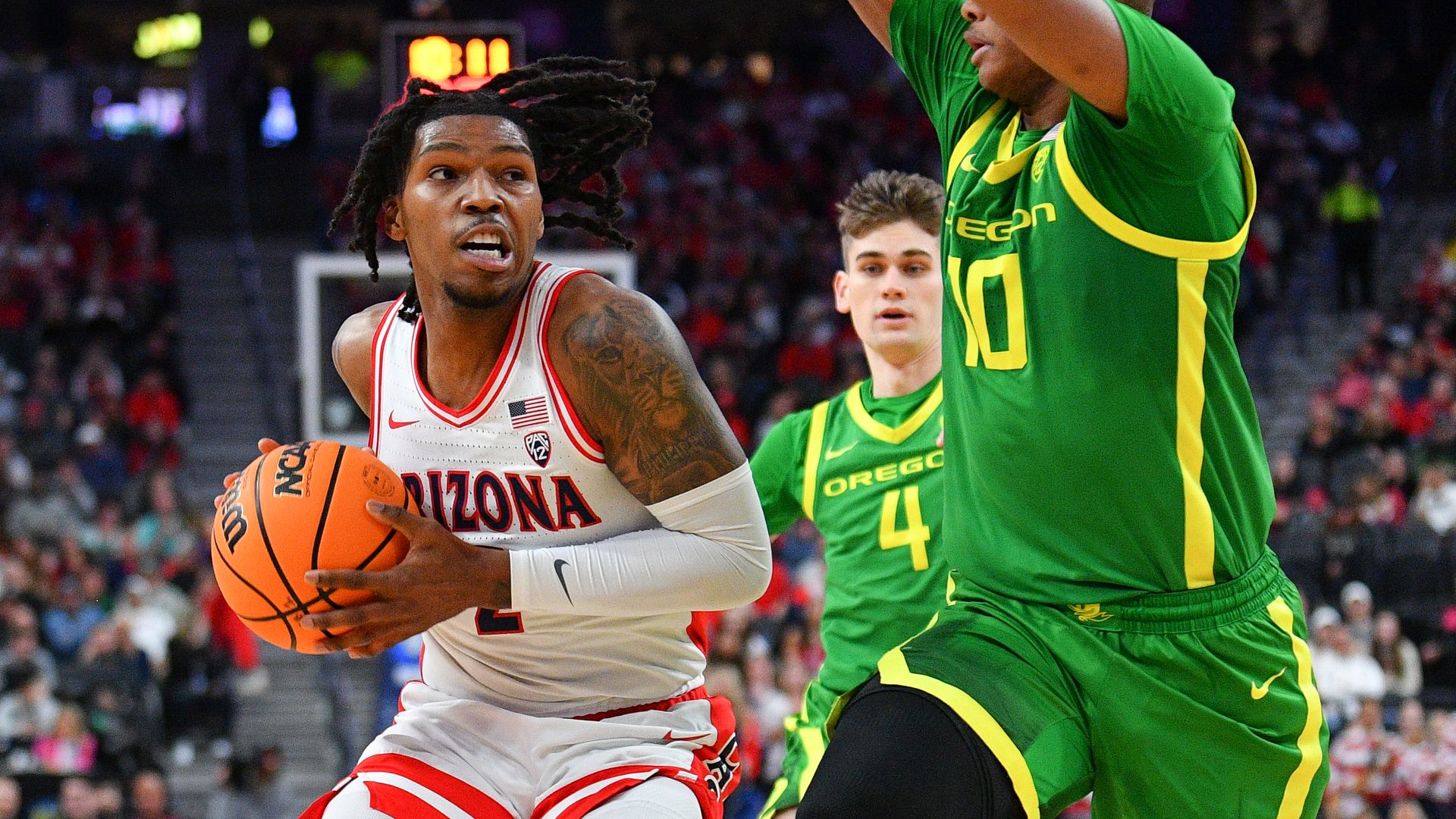 A basketball player drives against a defender. 