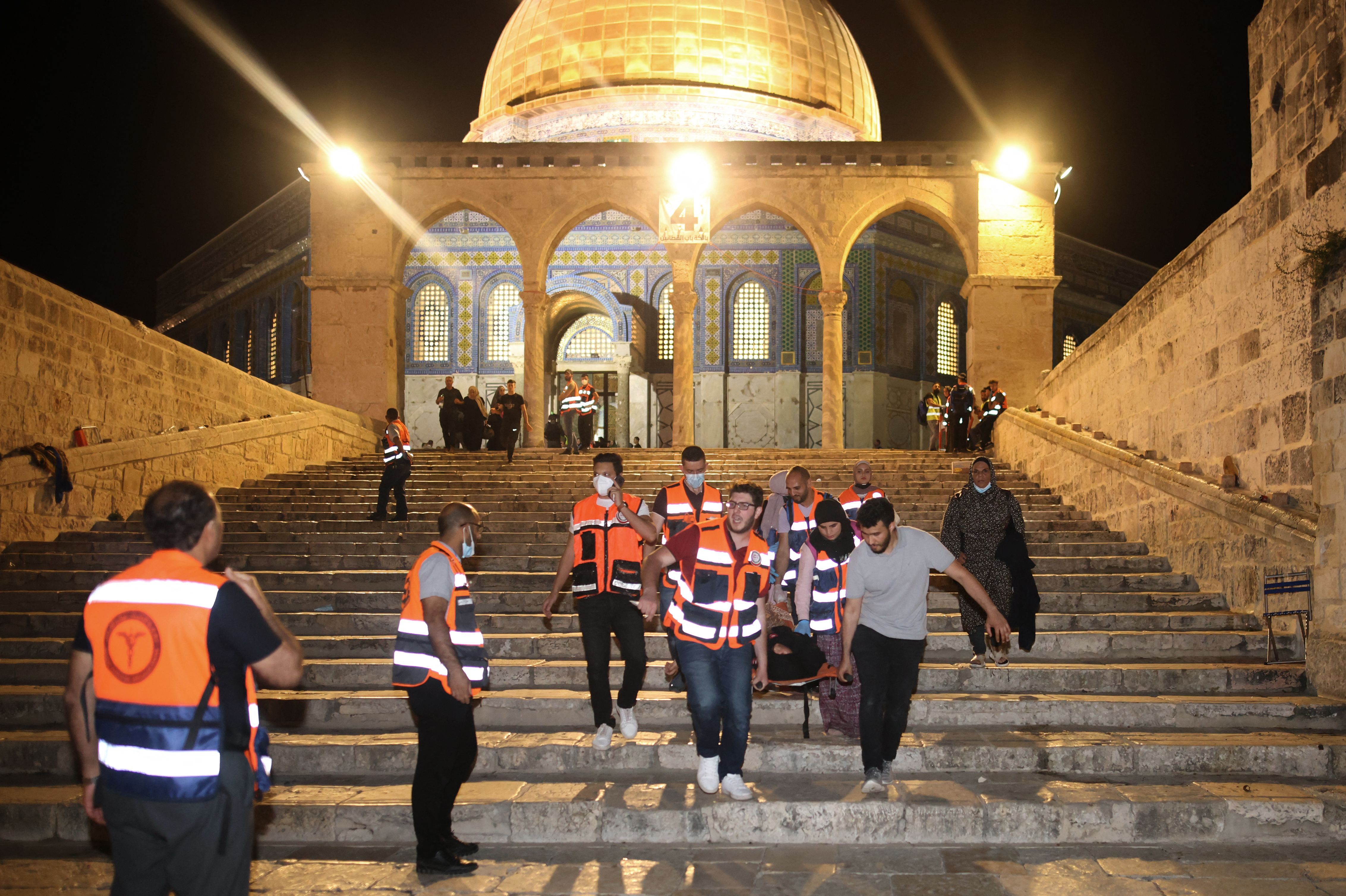 Palestinian medics evacuate a wounded person during clashes between Israeli security forces and Palestinian protestors in Jerusalem's al-Aqsa mosque compound on May 10