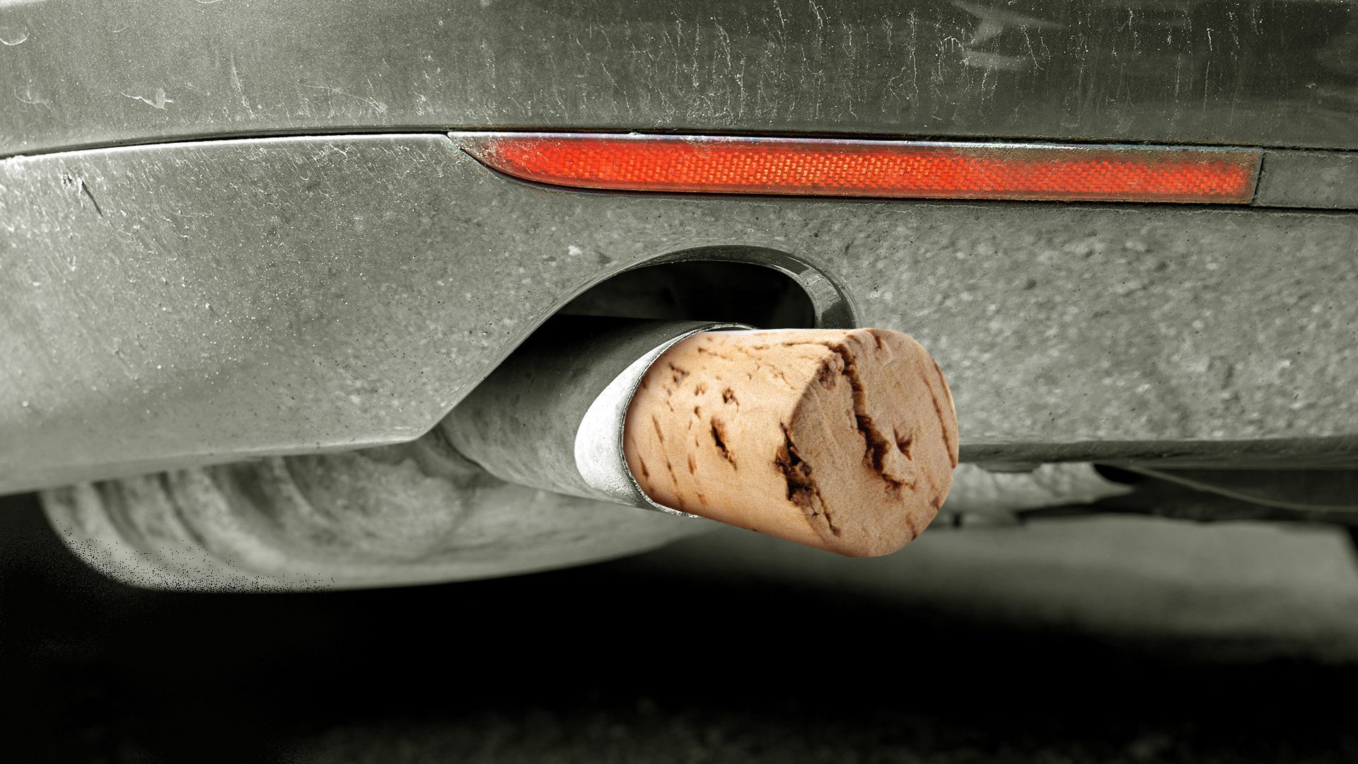 Illustration of a close up of a car exhaust pipe stuffed with a cork. 