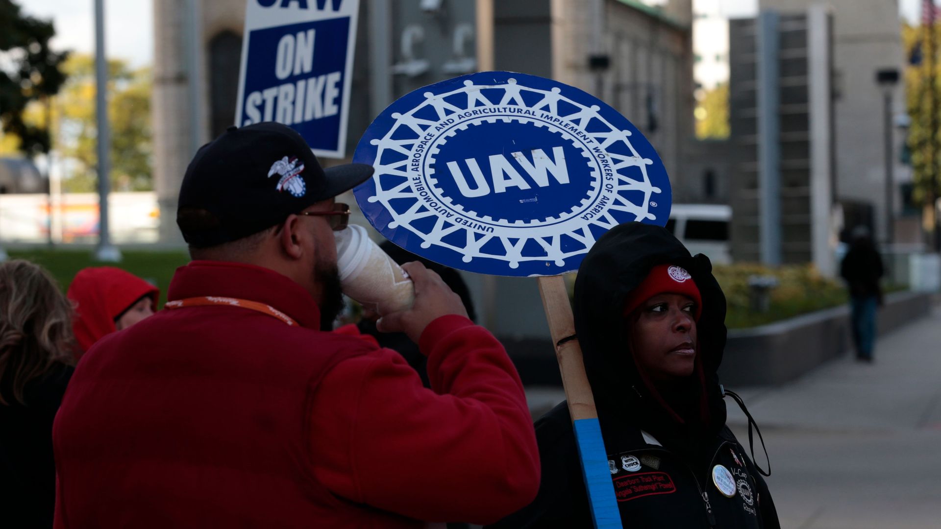 Members of the United Auto Workers picked outside of a building holding strike signs.