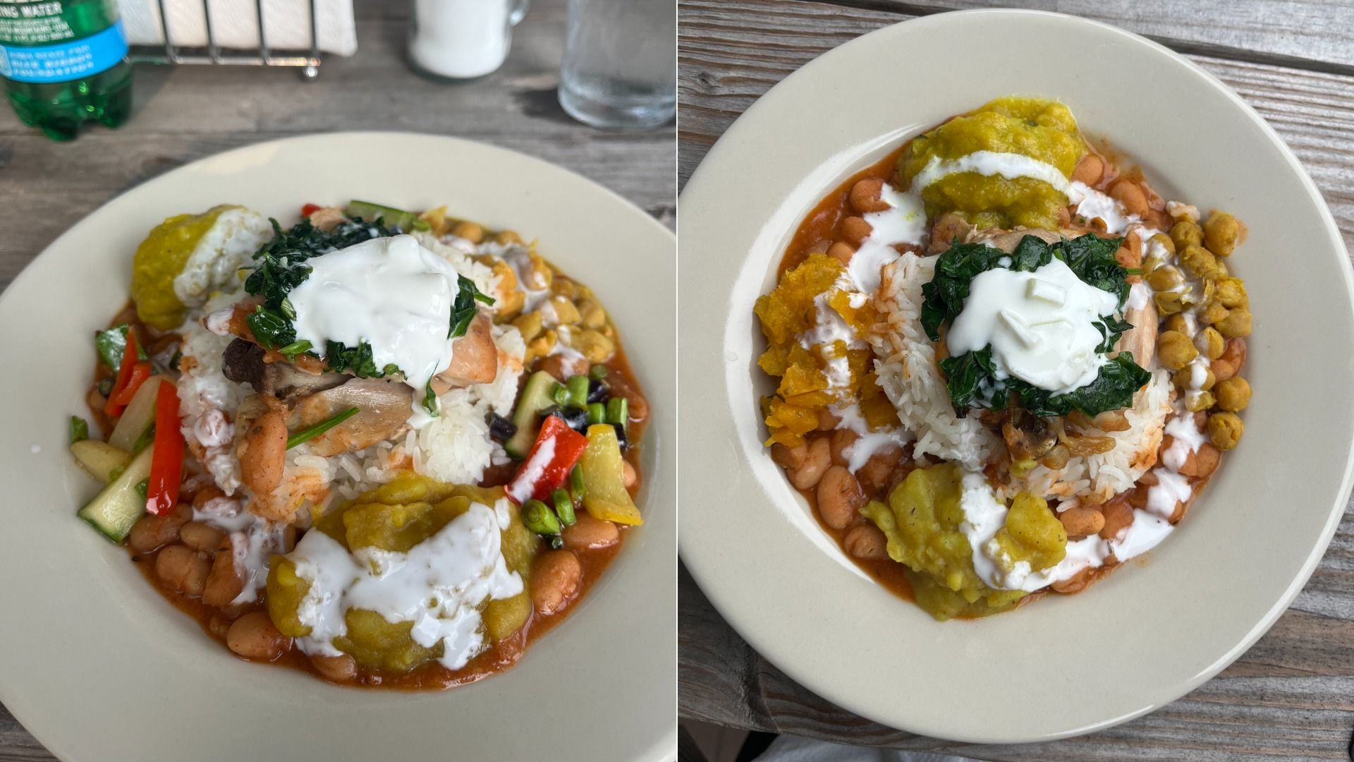 Two plates of colorful food with rice, beans, cooked greens, red and green vegetables, yellow fried plantains, and white sauce on top, served on a rustic wooden table.