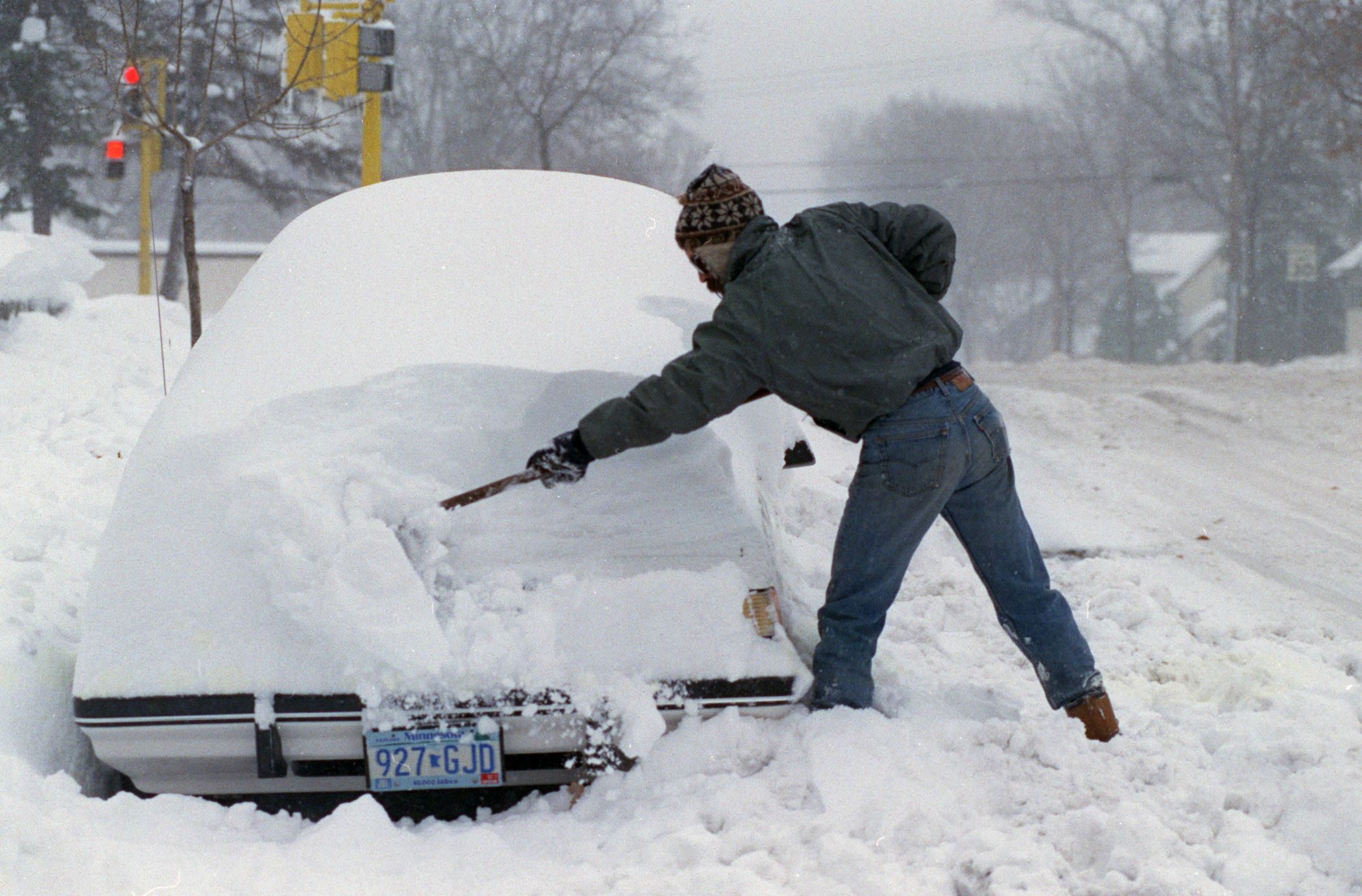 A man digging his car out of snow.