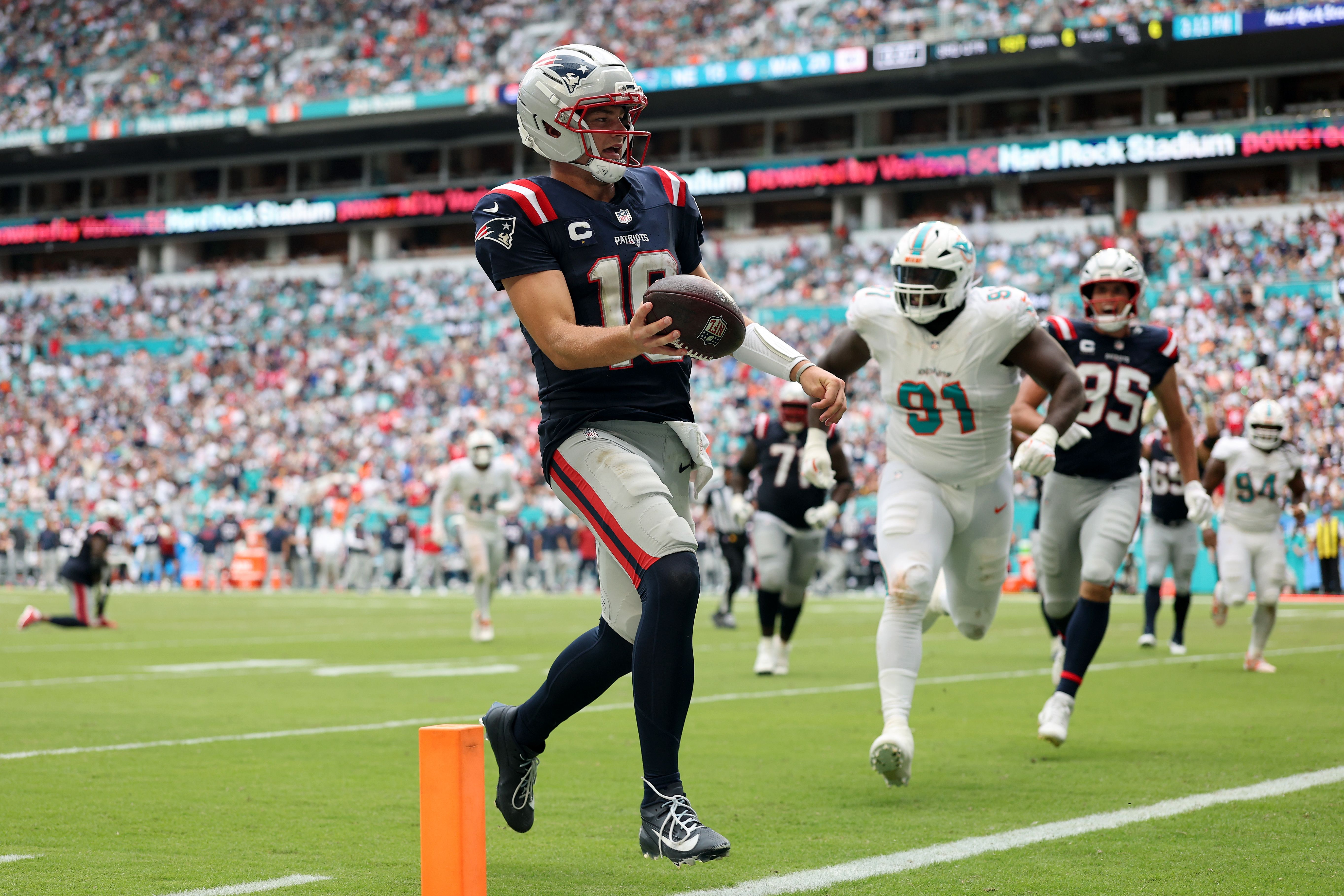 Drake Maye #10 of the New England Patriots scores a rushing touchdown against the Miami Dolphins during the second half in the game at Hard Rock Stadium on September 14, 2025 in Miami Gardens, Florida.