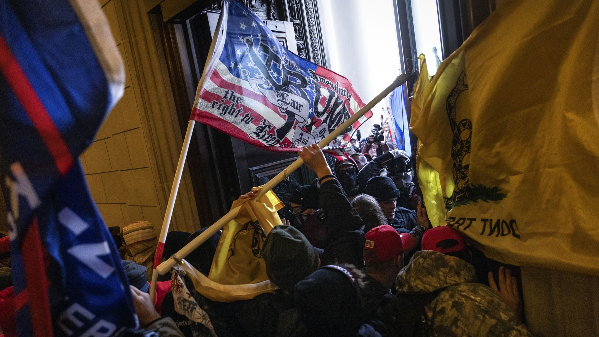 A pro-Trump mob breaks into the U.S. Capitol on Jan. 6, 2021, using flags.