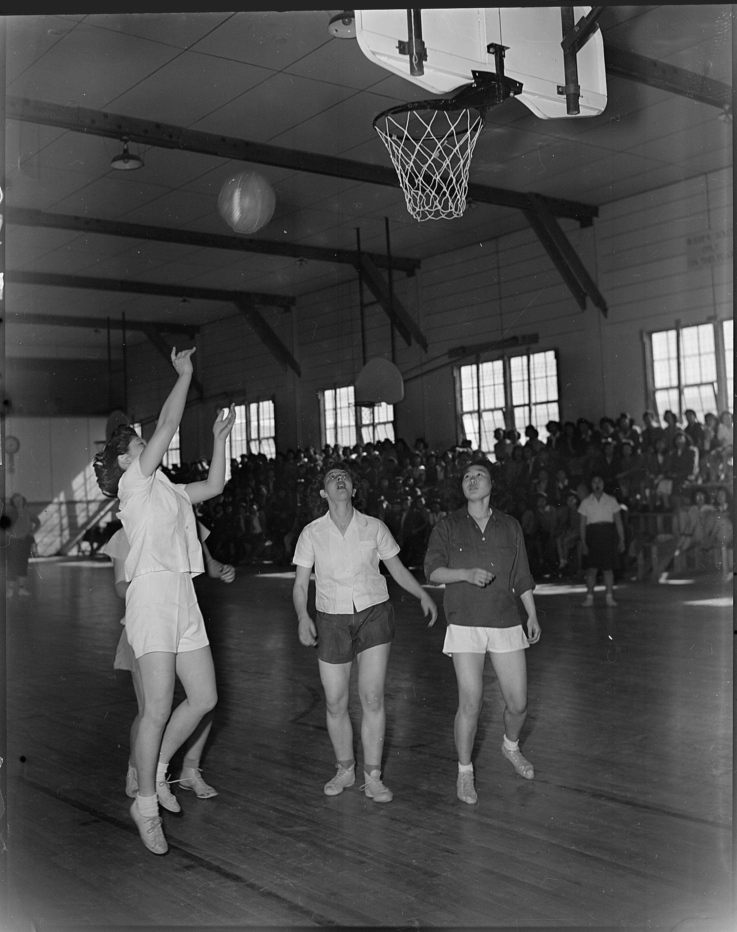 Girls playing basketball indoors.