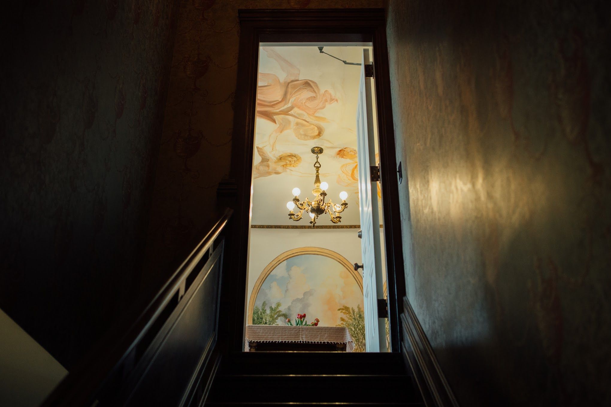 A photo of a doorway showing a glimpse of an apartment with murals.