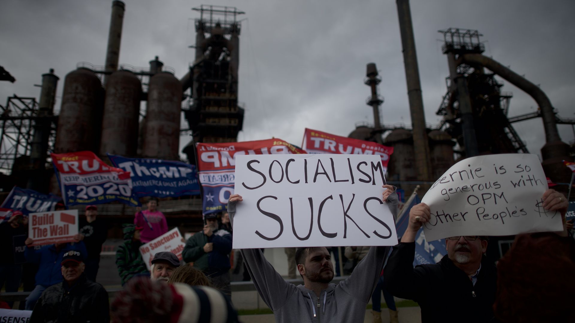 Donald Trump supporters demonstrate against Sen. Bernie Sanders with a "Socialism Sucks" sign.