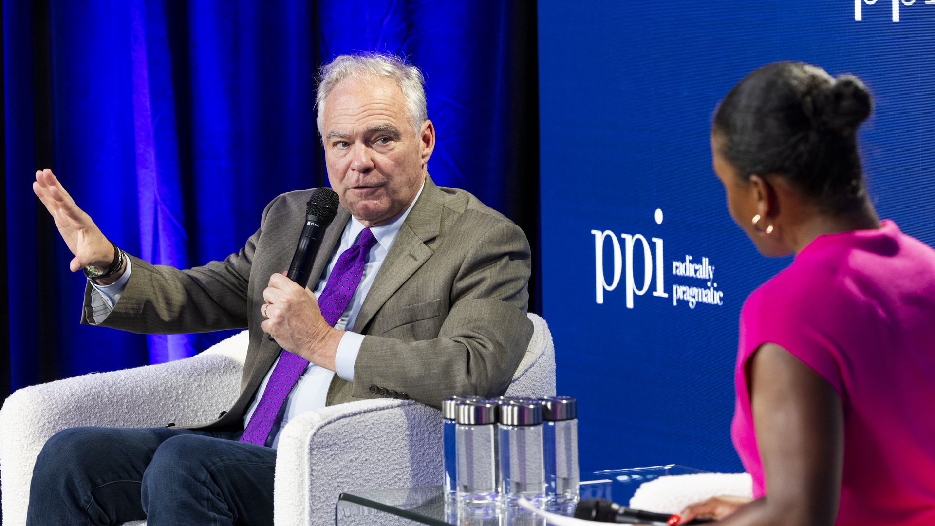 Sen. Tim Kaine sits on stage in conversation with Axios' Courtenay Brown
