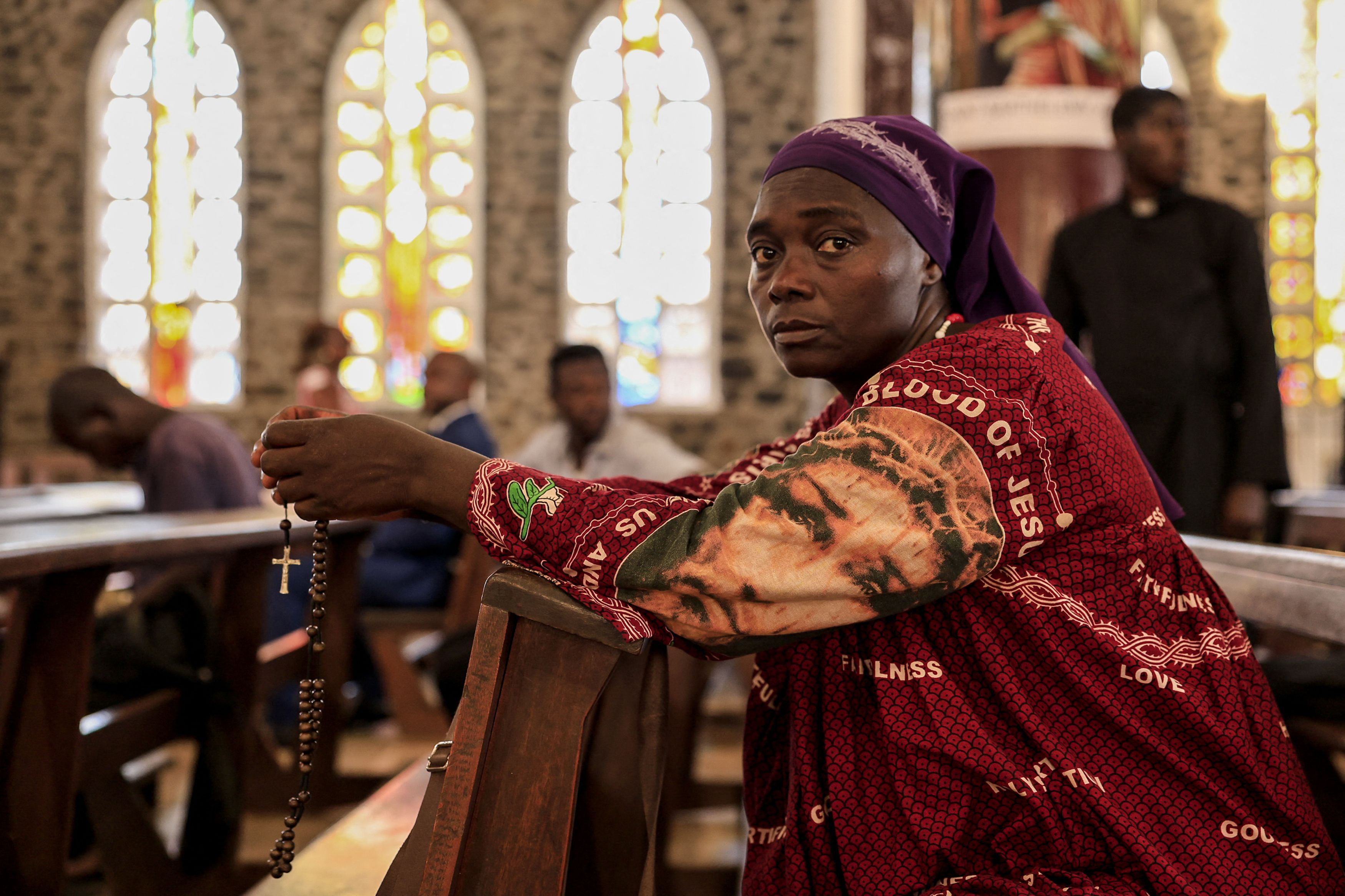 TOPSHOT - A believer reacts before the start of the tribute mass for Pope Francis in Notre Dame des Victoires Cathedral in Yaounde on April 21, 2025. Pope Francis died of a stroke on April 21, 2025 in the morning in The Vatican at the age of 88, a death that sparked a wave of emotion around the worl