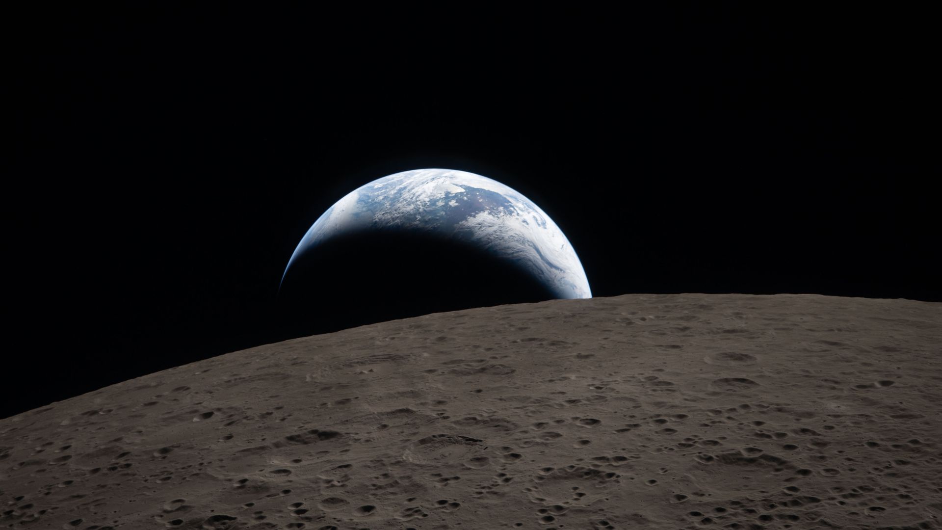 Earth appears on the lunar horizon from the cratered Moon surface, with blue oceans and white clouds against the dark space.