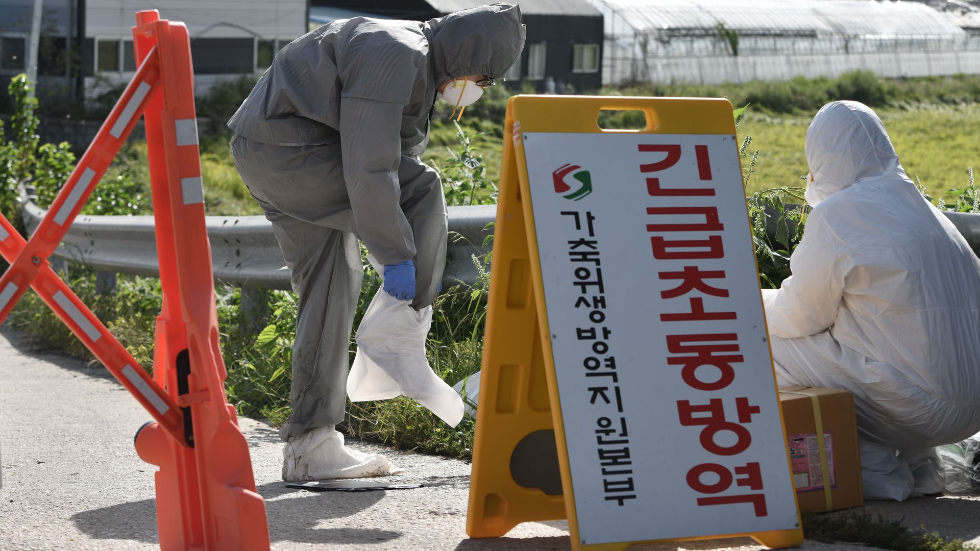 South Korean quarantine officials block people from entering an infected area.