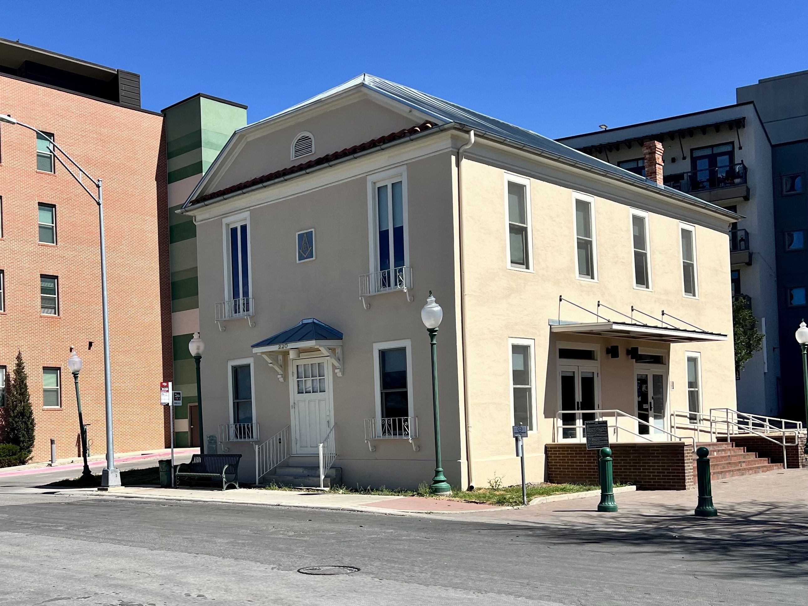 Beige two-story building with white trim and blue roof awnings